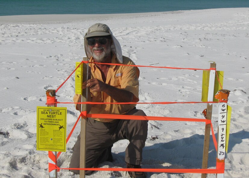 Sea Turtle Monitoring Program team volunteer, Jim Stalls, marks off a nest he found June 9 on Eglin's beaches. Mr. Stalls is one of more than 40 volunteers who help track and document sea turtle nesting from May 1 to Oct. 31. Eglin beaches are the birthplace of thousands of the federally listed endangered sea turtles like this one every year. (Courtesy photo.) 
