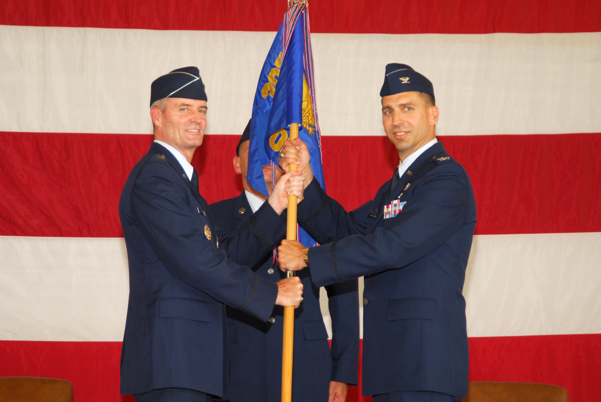 (Left) Brig. Gen. Darryl Roberson, 325th Fighter Wing commander, passes the guidon to Col. Wesley Hallman as he assumes command of the 325th Operations Group.