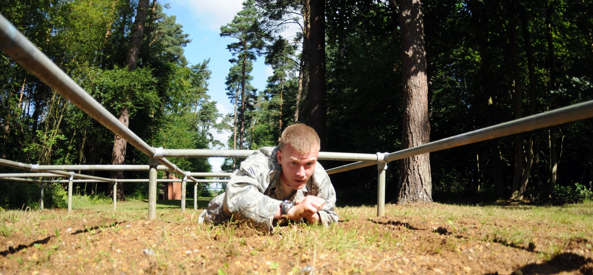 Senior Airman Johnny Keeton low crawls under an obstacle while training for the 2009 Air Mobility Rodeo July 10.  Airman Keeton is part of the five-man team from the 100th Security Forces Squadron training to compete against other security forces units at the competition at McChord Air Force Base, Wash. July 19 through 25.  (U.S. Air Force photo by Staff Sgt. Austin M. May)