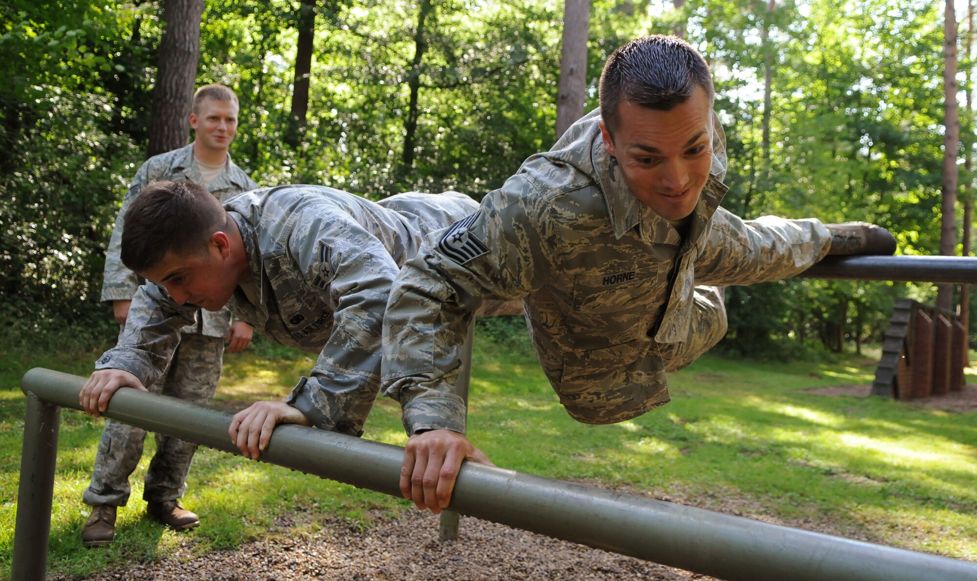 Airman 1st Class Matthew Pyland and Tech. Sgt. Allen Horne, 100th Security Forces Squadron, do push ups on a set of bars on the British army’s Stanford Training Area July 10 during a break from running the area’s obstacle course.  The Airmen running the course have been training for the 2009 Air Mobility Rodeo for 10 weeks, and most say they are now in the best shape of their lives.  (U.S. Air Force photo by Staff Sgt. Austin M. May)
