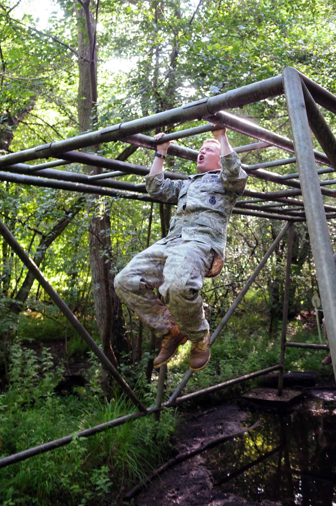 Senior Airman Johnny Keeton, having just swung his way over a watery pit beneath a set of monkey bars at the British army’s Stanford Training Area obstacle course July 10, knocks out a set of pull-ups.  The Airman is part of a five-man team training to compete with the 100th Air Refueling Wing at the 2009 Air Mobility Rodeo.  (U.S. Air Force photo by Staff Sgt. Austin M. May)