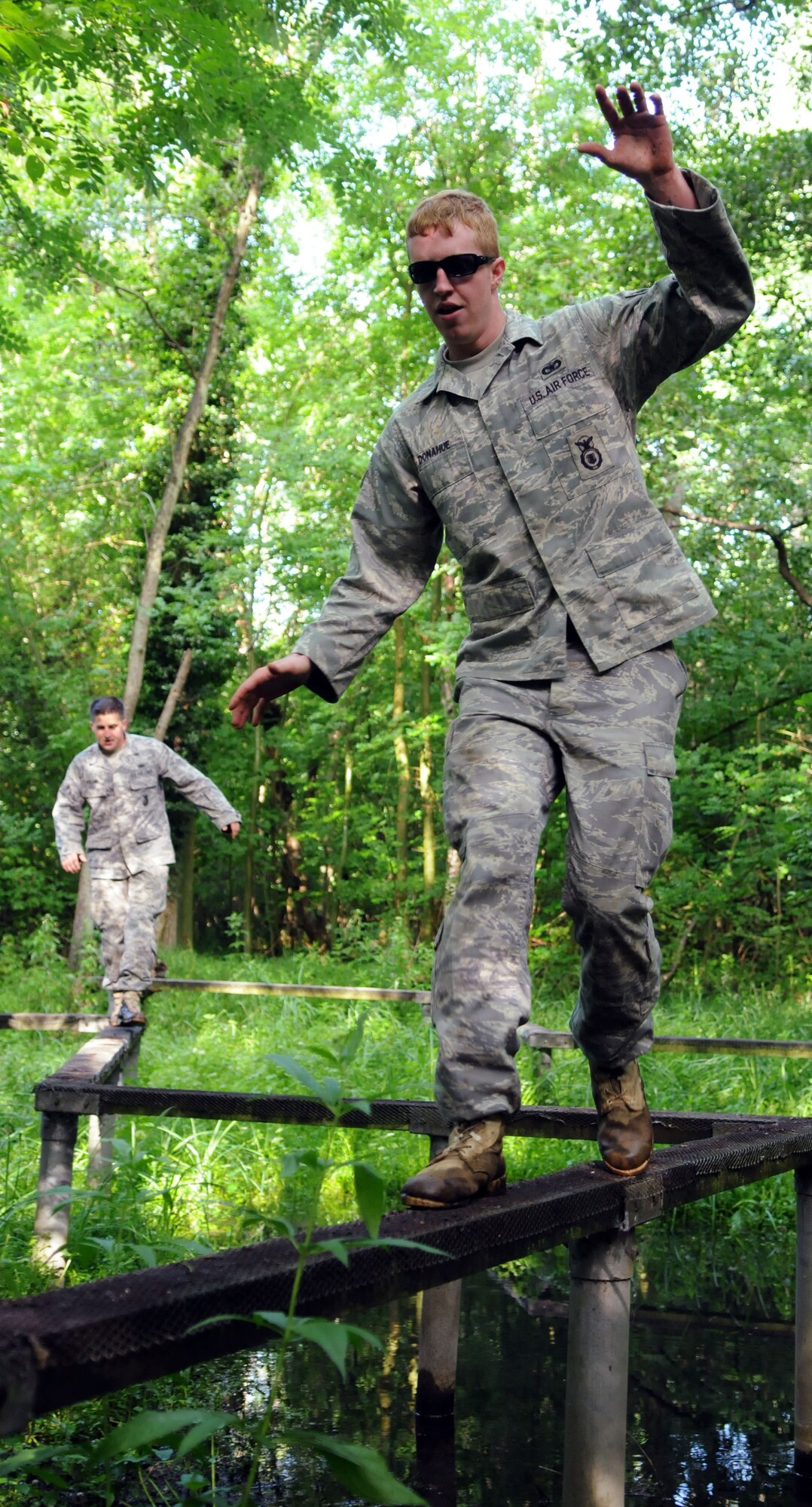 Senior Airman Joseph Donahue, 100th Security Forces Squadron, negotiates a balance beam over a shallow pond while completing an obstacle course at the British army’s Stanford Training Area July 10.  The obstacle course was tackled by the five members of the 100th SFS team preparing to compete in the 2009 Air Mobility Rodeo.   (U.S. Air Force photo by Staff Sgt. Austin M. May)