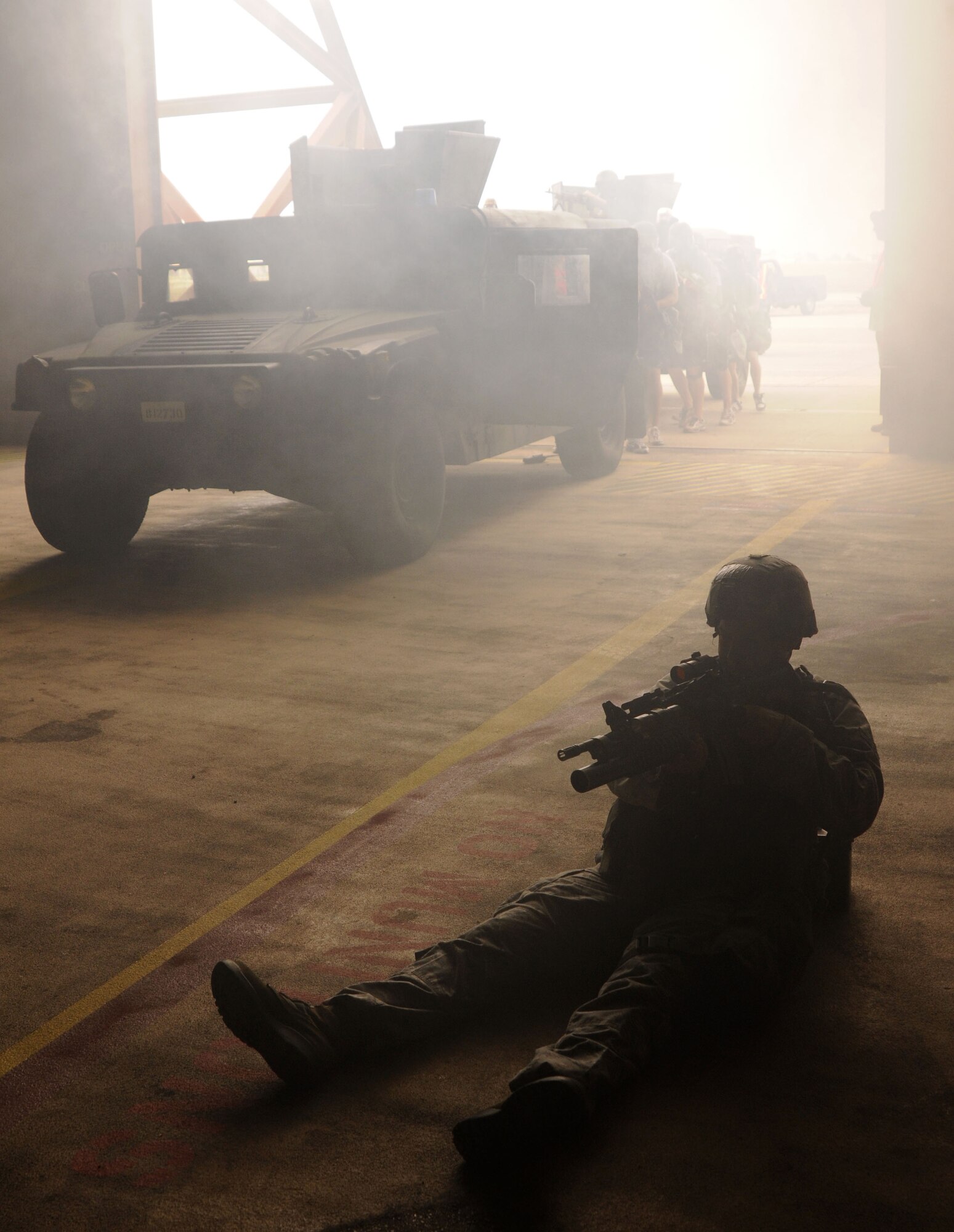 As more Airmen from 39th Security Forces Squadron enter a protective aircraft shelter, a wounded SF member keeps his sight on simulated adversaries Wednesday, July 8, 2009, during an exercise at Incirlik Air Base, Turkey. An exercise evaluation team evaluated participating squadrons on their exercise responses. (U.S. Air Force photo/Airman 1st Class Amber Russell)