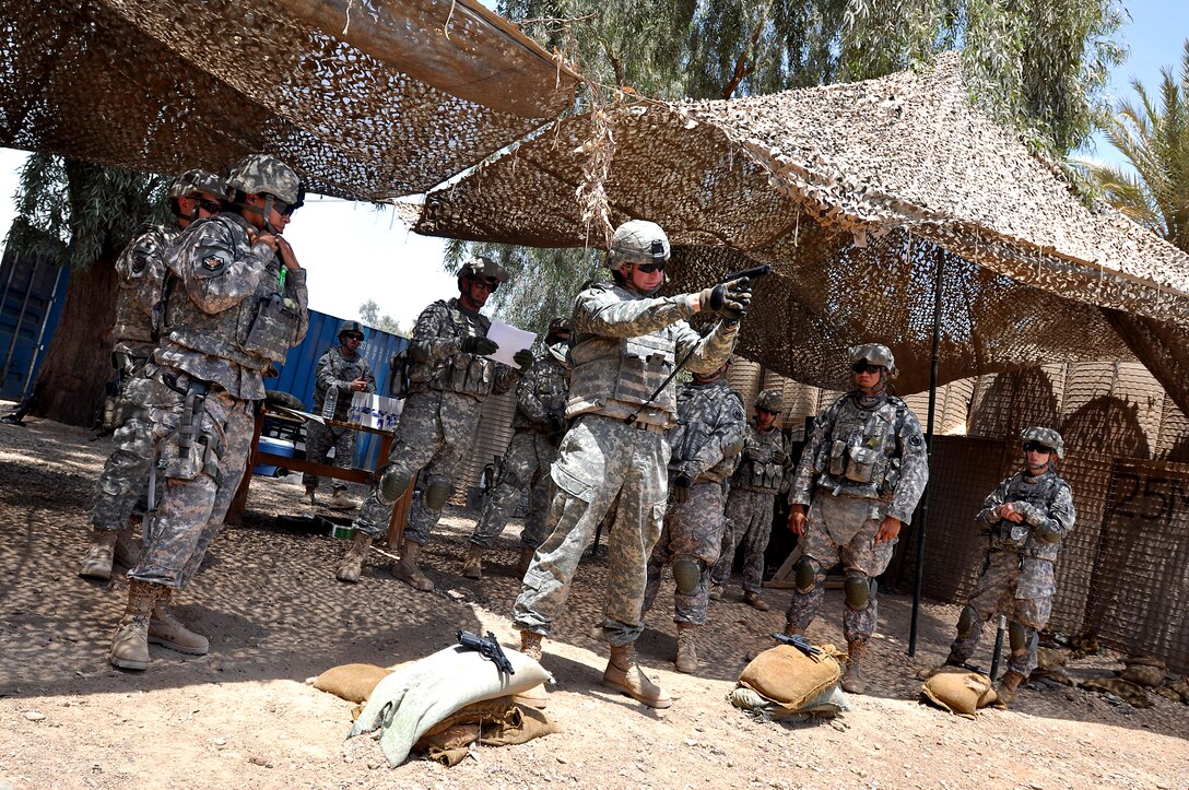 U.S. Army Sgt. Bryan Tull demonstrates how to properly handle a 9mm Beretta pistol while standing for training purposes at Prosperity Range on Forward Operating Base Prosperity, Baghdad, July 11, 2009. Tull is the range non-commissioned officer in charge, and assigned to the 314th Public Affairs Operation Center.