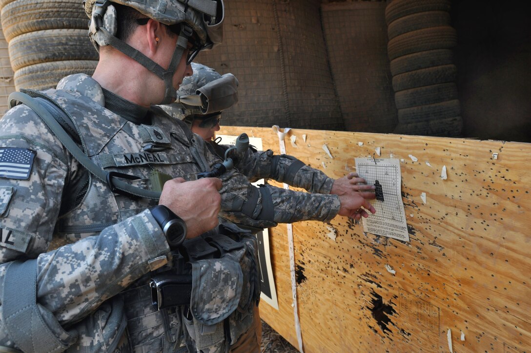 U.S. Army Staff Sgt. Sean McNeal, left, and Sgt. Jennifer Marquart check her target to make sure she is breathing correctly as she qualified with her 9mm Beretta pistol and M4 Carbine at Prosperity Range on Forward Operating Base Prosperity, Baghdad, July 11, 2009. Marquart is a technician assigned to the 222nd Broadcast Operations Detachment.