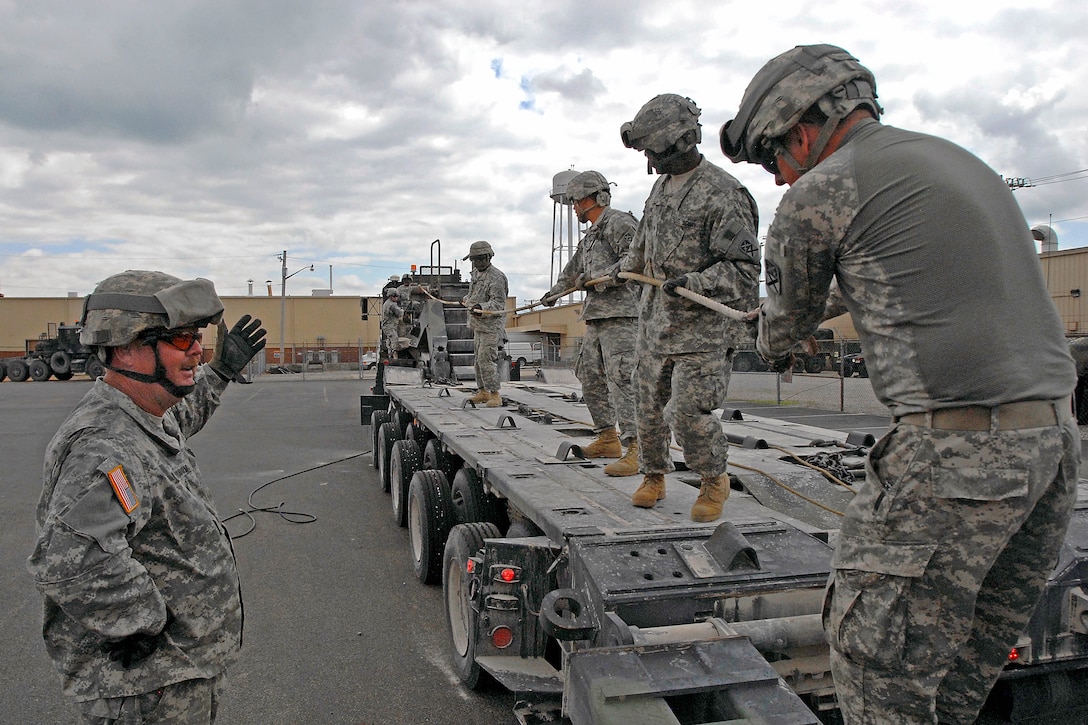 U.S. Army soldiers secure a cable from a vehicle designed to transport heavy equipment at the National Guard Armory in Bluffton, Ind., June 30, 2009. The soldiers are assigned to the 2025th Transportation Company, and are undergoing mobilization training by the 205th Infantry Brigade to prepare for deployment to Iraq.