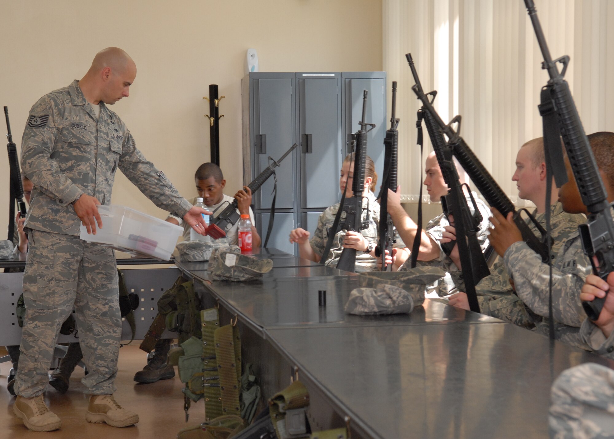 MISAWA AIR BASE, Japan -- Tech. Sgt. Jesse Cudzilo, 35th Security Forces Squadron combat arms instructor, hands out magazines during an augmentation force training class July 9 at the combat arms training building. Airmen and sailors learn how to handle an M-16 rifle safely during a five day augmentation force program. (Air Force photo/Staff Sgt. Phillip Butterfield)