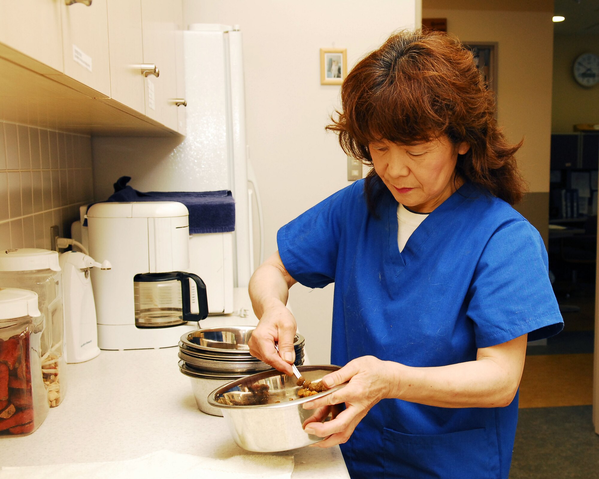 YOKOTA AIR BASE, Japan -- Mariko Yokozawa, 374th Force Support Squadron Pet Care Center manager, prepares food for dogs at the center July 15. The Pet Care Center, available for all registered pets on Yokota, is open daily from 8:30 a.m. to noon and from 4 to 7 p.m. Customers who want to board their dog, must make sure the dog has received the DA2PPL-CV and a rabies vaccination within 12 months and the Bordetella (kennel cough) vaccine within five days prior to entering the kennel. (U.S. Air Force photo/Airman First Class Sean Martin)