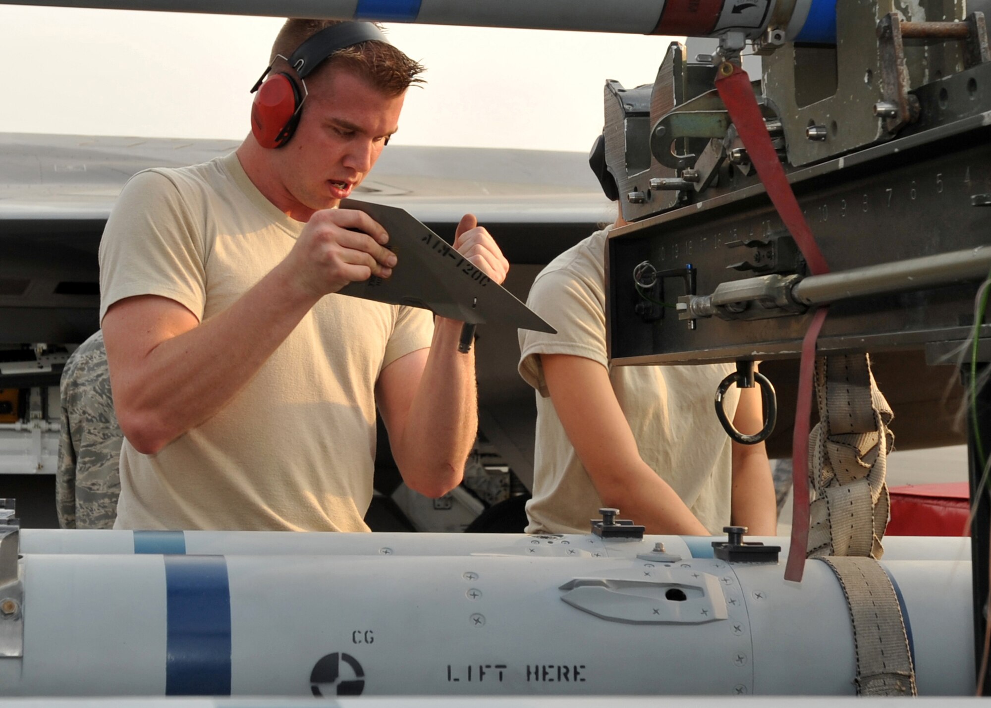 ELMENDORF AIR FORCE BASE, Alaska -- Airman 1st Class Daniel Kok, 3rd Aircraft Maintenance Squadron, installs an AIM-120 missile wing during a load crew competition July 10. The purpose of the competition is to demonstrate and be tested on quick turn weapon loads. Kok is a member of the 3rd Aircraft Maintenance Squadron. (U.S. Air Force photo/Senior Airman Laura Turner)