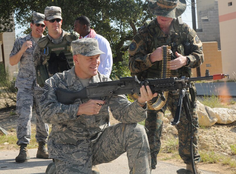 Chief Master Sergeant of the Air Force James A. Roy fires an M240B medium machine gun during his visit to Movement Over Urban Terrain training for security forces technical school students July 9 at Lackland Air Force Base, Texas. (Photo by Joel Martinez)