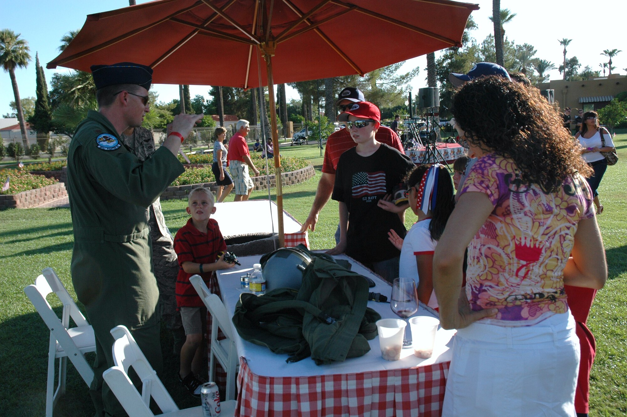 Maj. Michael Meyer, 301st Fighter Squadron instructor pilot, talks with local community members at the Fourth of July celebration at the Wigwam Golf Resort and Spa in Litchfield Park, Ariz. Major Meyer explained the F-16's manuevers, the purposes of the G-suit, and demonstrated night vision goggles to help inform the community on the roles of the Air Force Reserve. (U.S. Air Force photo/Tech. Sgt. Susan Stout)