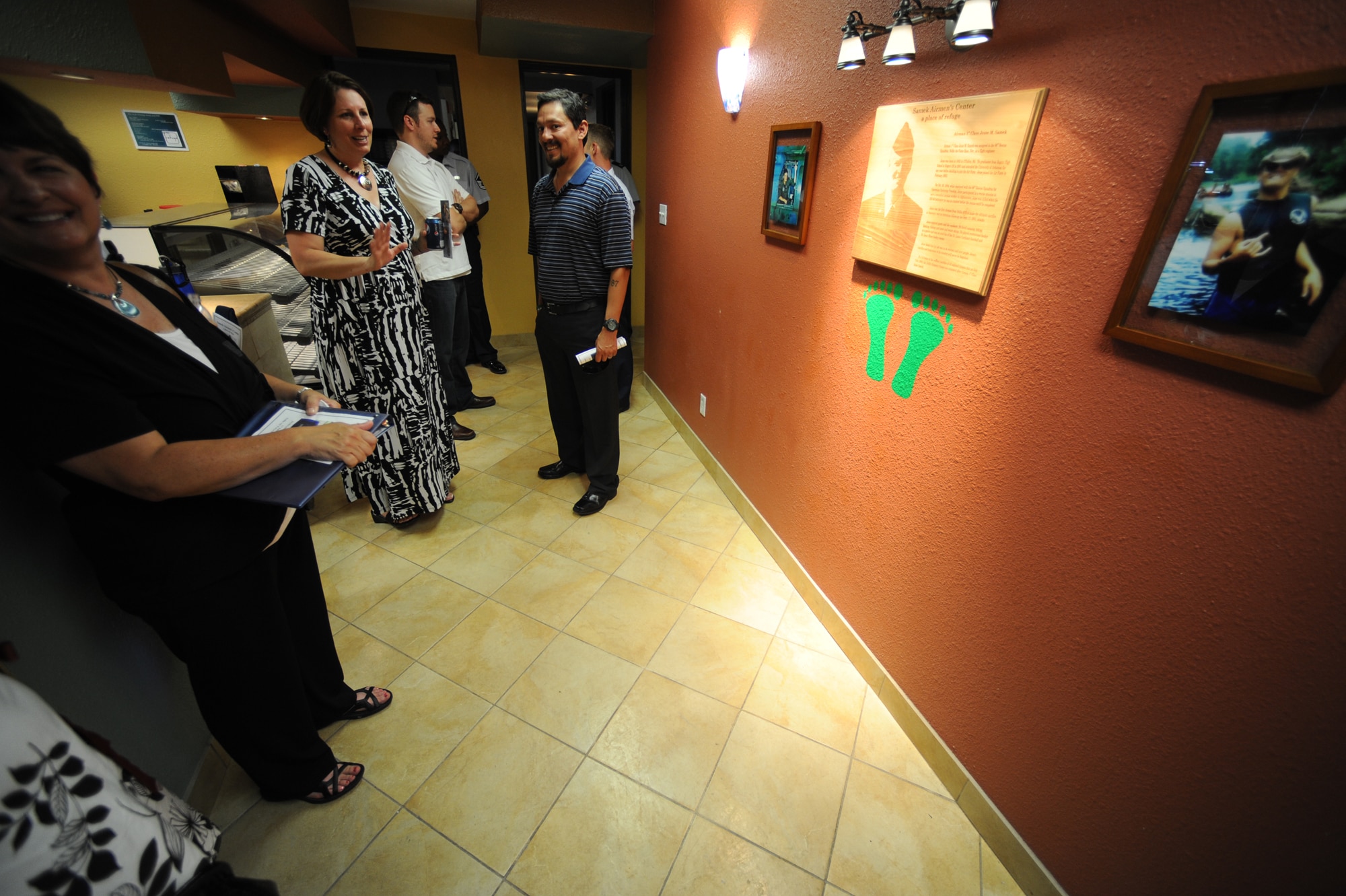 Mrs. Julia Samek mother of Airman 1st Class Jesse Samek admires an engraved wooden plaque in memory of her son during the Samek Airmen's Center Dedication ceremony at Nellis Air Force Base on July 13, 2009. The newly renovated Airmen's Center is renamed in honor of Airman Samek. Samek was killed when his HH-60 helicopter crashed during a rescue mission in Afghanistan in 2004. Samek was the first Airman from Nellis Air Force Base to sacrifice his life in the war on terrorism following the Sept. 11, 2001 attacks.  (U.S. Air Force Photo/Tech. Sgt. Michael R. Holzworth)

