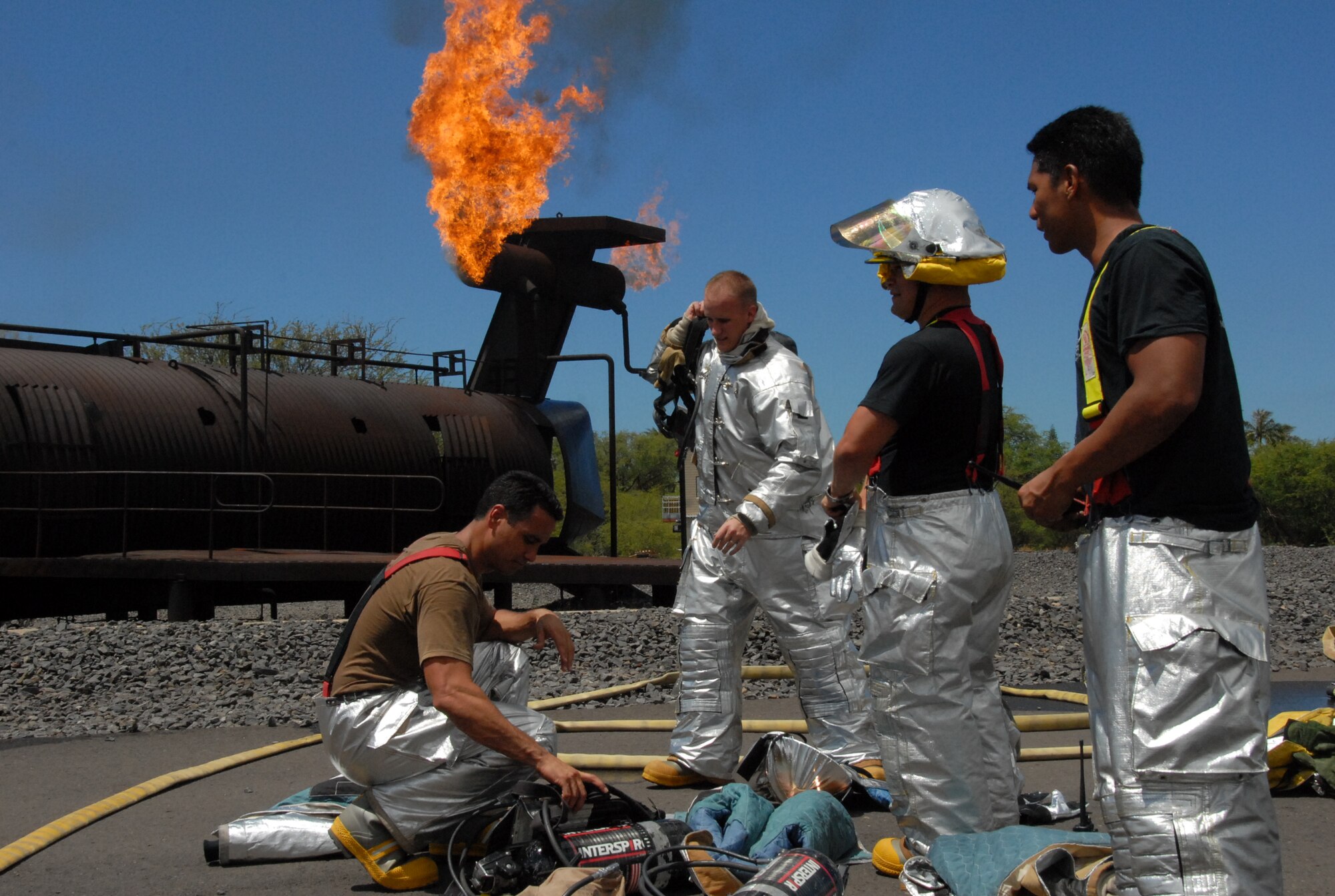 Staff Sgt. Frank Abreu, 15th Civil Engineer Squadron, and Staff Sgt. Jonathan “Kaipo” Onekea, 624th CES, prepare their fire gear for their annual aircraft live fire burn training requirement. The 624th CES Fire Department coordinates required training with the host 15th CES Fire Department when they require use of facilities or need training resources such as the 15th CES aircraft live fire training facility to accomplish annual training requirements. (Air Force photo/Capt. Christy Stravolo)