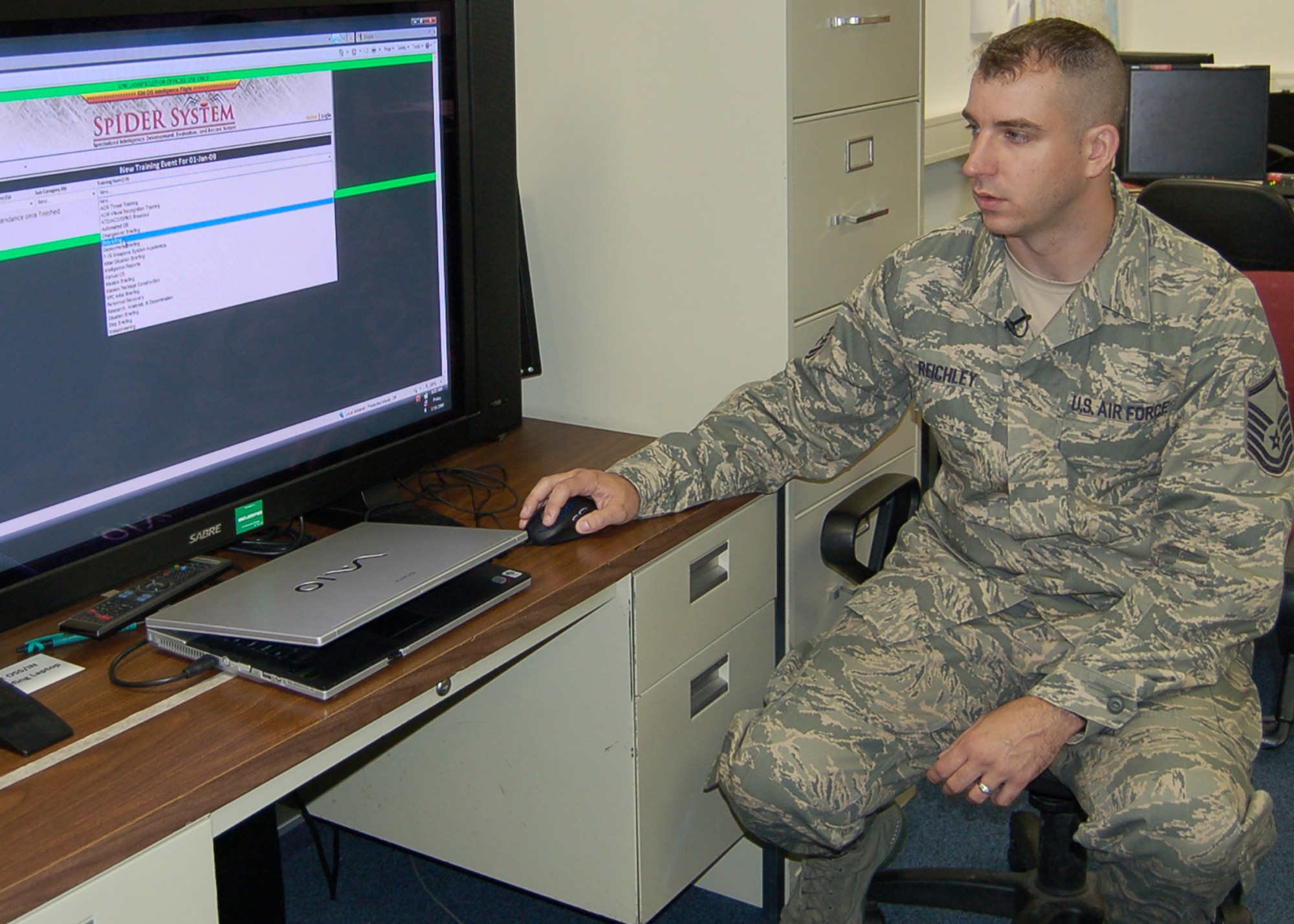 Master Sgt. Erich Reichley monitors training progress in his shop through the Specialized Intelligence Development, Evaluation and Record System at Spangdahlem Air Base, Germany. Sergeant Reichley created the "SpIDER System" for his shop to track training. He earned $10,000 for his efforts through the Innovative Development Through Employee Awareness Program. Sergeant Reichley is the 52nd Operations Support Squadron NCO in charge of intelligence operations. (U.S. Air Force photo/Tech. Sgt. Tammie Moore) 