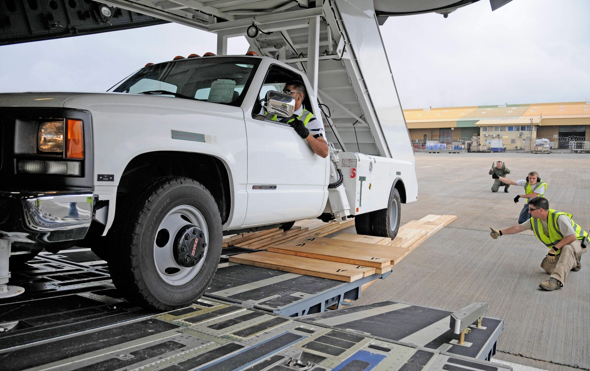 Members of the 621st Contingency Response Wing along with C-17 Globemaster III aircrew members work together to ensure proper clearance during offloading operations of a stair truck at Kotoka International Airport July 6 at Accra, Ghana. The Airmen are among more than 150 Airmen, Sailors and Marines in Ghana and Sailors aboard the USS Iwo Jima who form a task force supporting President Barack Obama's visit July 10 and 11. Members from the 621st CRW are from McGuire Air Force Base, N.J., and the C-17 aircrew is from Charleston Air Force Base, S.C. (U.S. Air Force photo/Staff Sgt. Jerry Fleshman) 