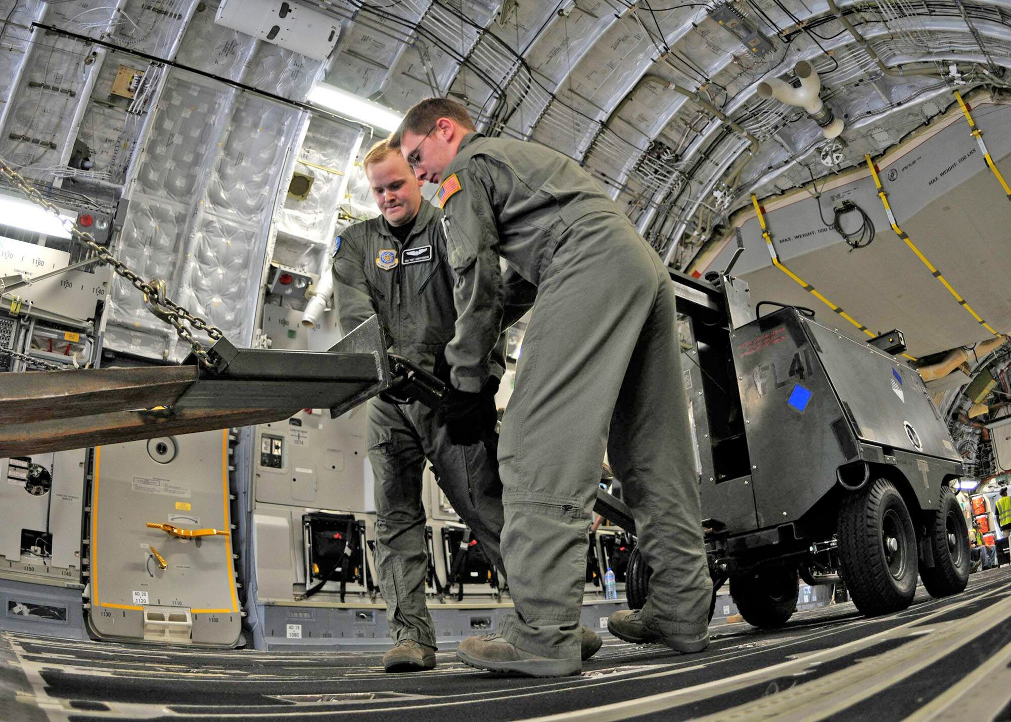 Senior Airmen Toby Christiensen and Paul Hedges connect a floodlight to a forklift during offloading operations of aerospace ground equipment at Kotoka International Airport July 6 at Accra, Ghana. The Airmen are among more than 150 Airmen, Sailors and Marines in Ghana and Sailors aboard the USS Iwo Jima who form a task force supporting President Barack Obama's visit July 10 and 11. Airmen Christiensen and Hedges are loadmasters with the 8th Airlift Squadron from McChord Air Force Base, Wash. (U.S. Air Force photo/Staff Sgt. Jerry Fleshman) 