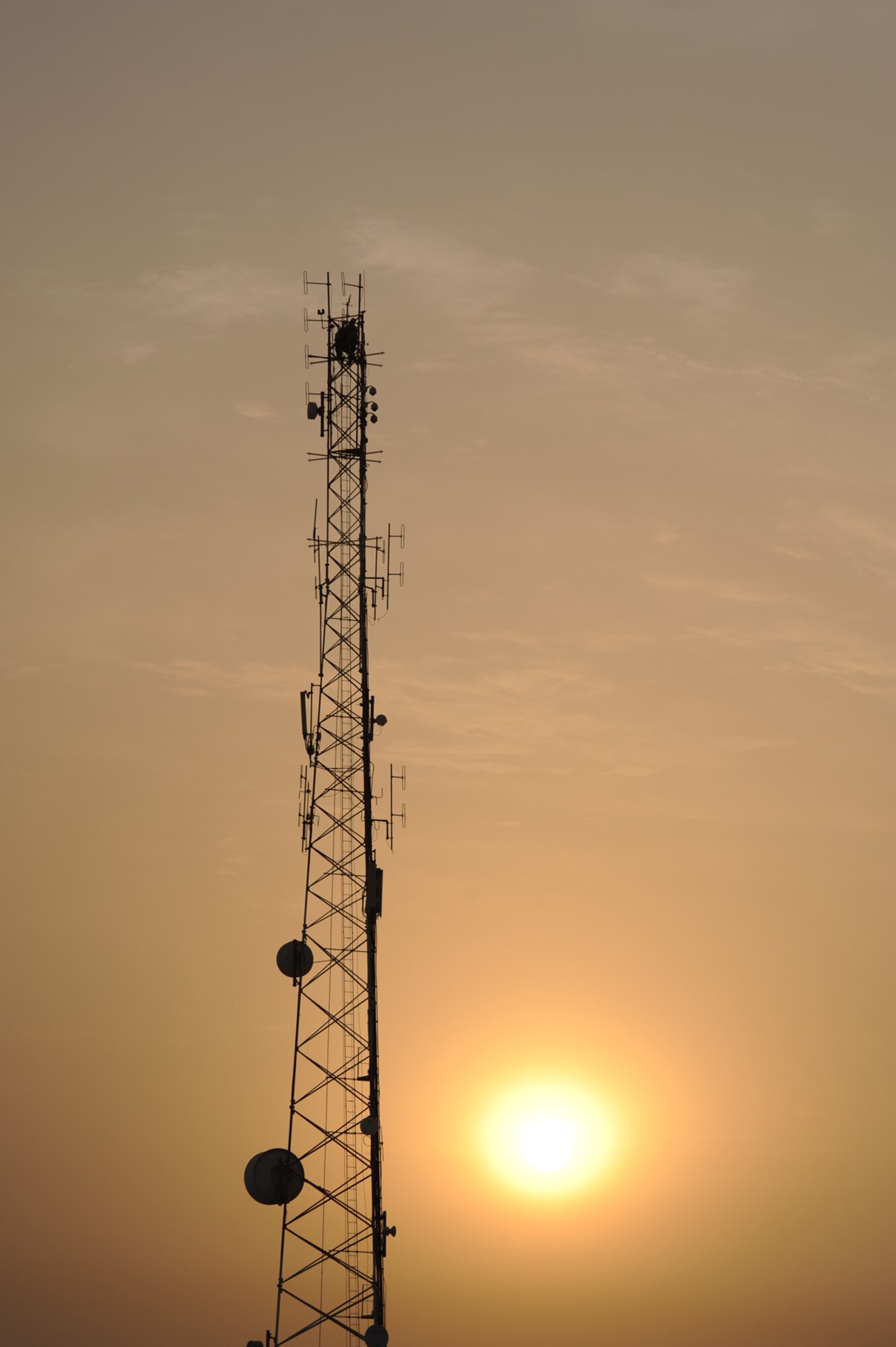 Airmen install a grounded lightening rod on top a 140-foot communications tower, July 12, in Southwest Asia. The lightening rod will provide better protection to local communications capabilities during imclement weather. (U.S. Air Force Photo/Staff Sgt. Robert Barney)