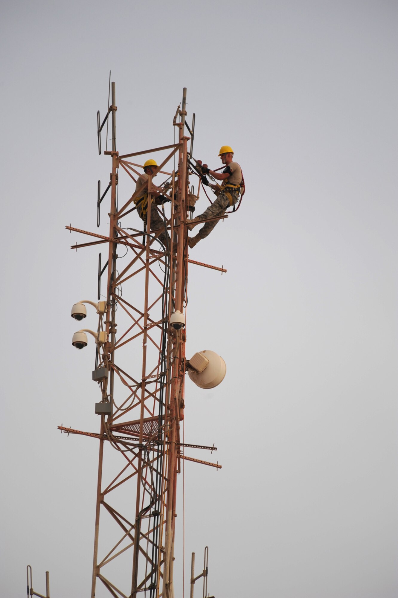 Left, Staff Sgt. Michael Worhach and Senior Airman Cody Updegrave, Air Force Forces Director of Communications and Installation Support Unit cable and antenna system installers, install a grounded lightening rod on top a 140-foot communications tower, July 12, in Southwest Asia. The lightening rod will provide better protection to local communications in case of lightening. Sergeant Worhach is a native of Tower City, Pa. and Airman Updegrave is from Lebanon, Pa. They are both deployed from the 211th Engineering Installation Squadron, Pennsylvania Air National Guard in support of Operations Iraqi and Enduring Freedom. (U.S. Air Force Photo/Staff Sgt. Robert Barney)