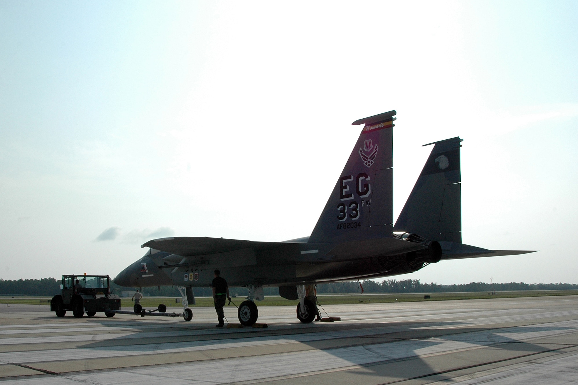 Members of the 33rd Maintenance Squadron follow along with an F-15A as it is towed across the flightline on Eglin Air Force Base, Fla., to its new home in front of the Northwest Florida Regional Airport July 13. Since 1978, 33rd Fighter Wing F-15s have flown over Eglin and the local community.  The last one will exit in September, just before the wing transitions to an F-35 Joint Strike Fighter training unit under Air Education and Training Command Oct. 1. (U.S. Air Force photo/Staff Sgt. Bryan Franks.)
