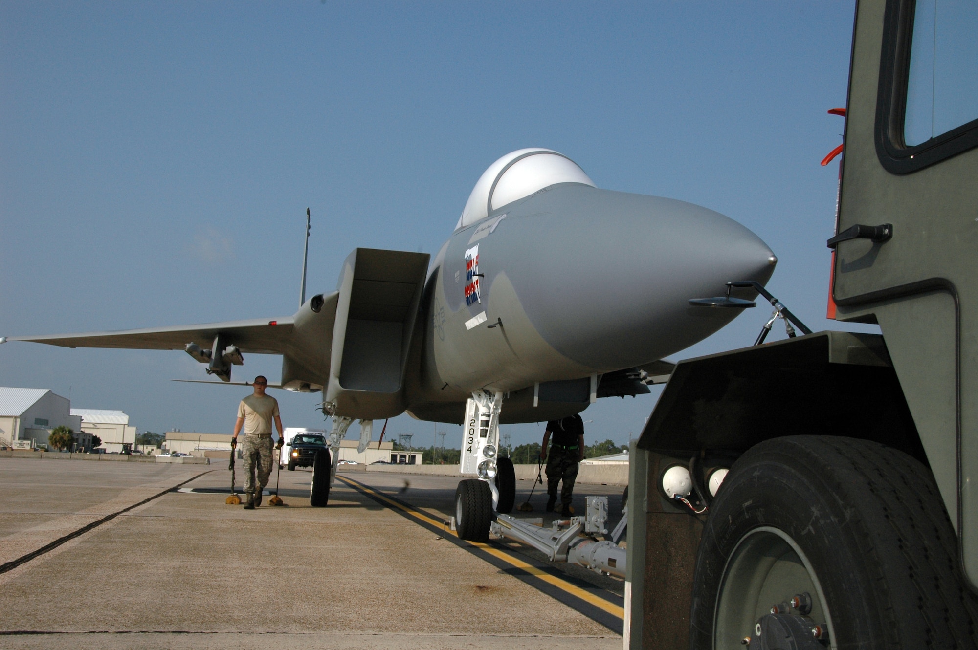 Members of the 33rd Maintenance Squadron follow along with an F-15A as it is towed across the flightline on Eglin Air Force Base, Fla to its new home in front of the Northwest Florida Regional Airport July 13. Since 1978, 33rd Fighter Wing F-15s have flown over Eglin and the local community.  The last one will exit in September, just before the wing transitions to an F-35 Joint Strike Fighter training unit under Air Education and Training Command Oct. 1.  (U.S. Air Force photo/Staff Sgt. Bryan Franks.)