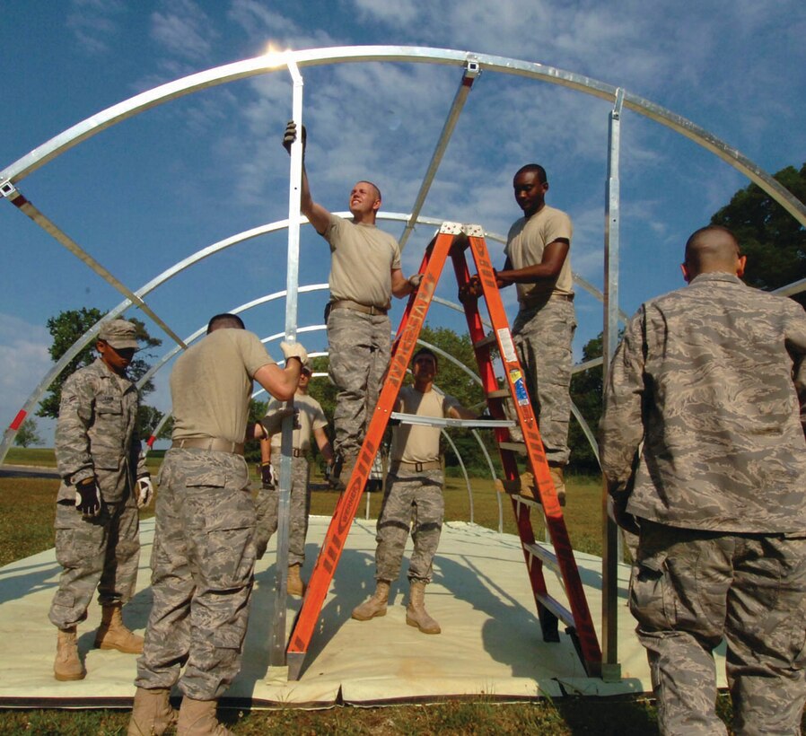 Members from the 316th Civil Engineer Squadron’s Prime Base Engineer Emergency Force raise a small shelter system during a monthly deployment contingency training session held on the east side of Andrews. During the session a 20-man team learned how to setup and dismantle a tent while forward deployed. (U.S. Air Force photo/ Bobby Jones)
