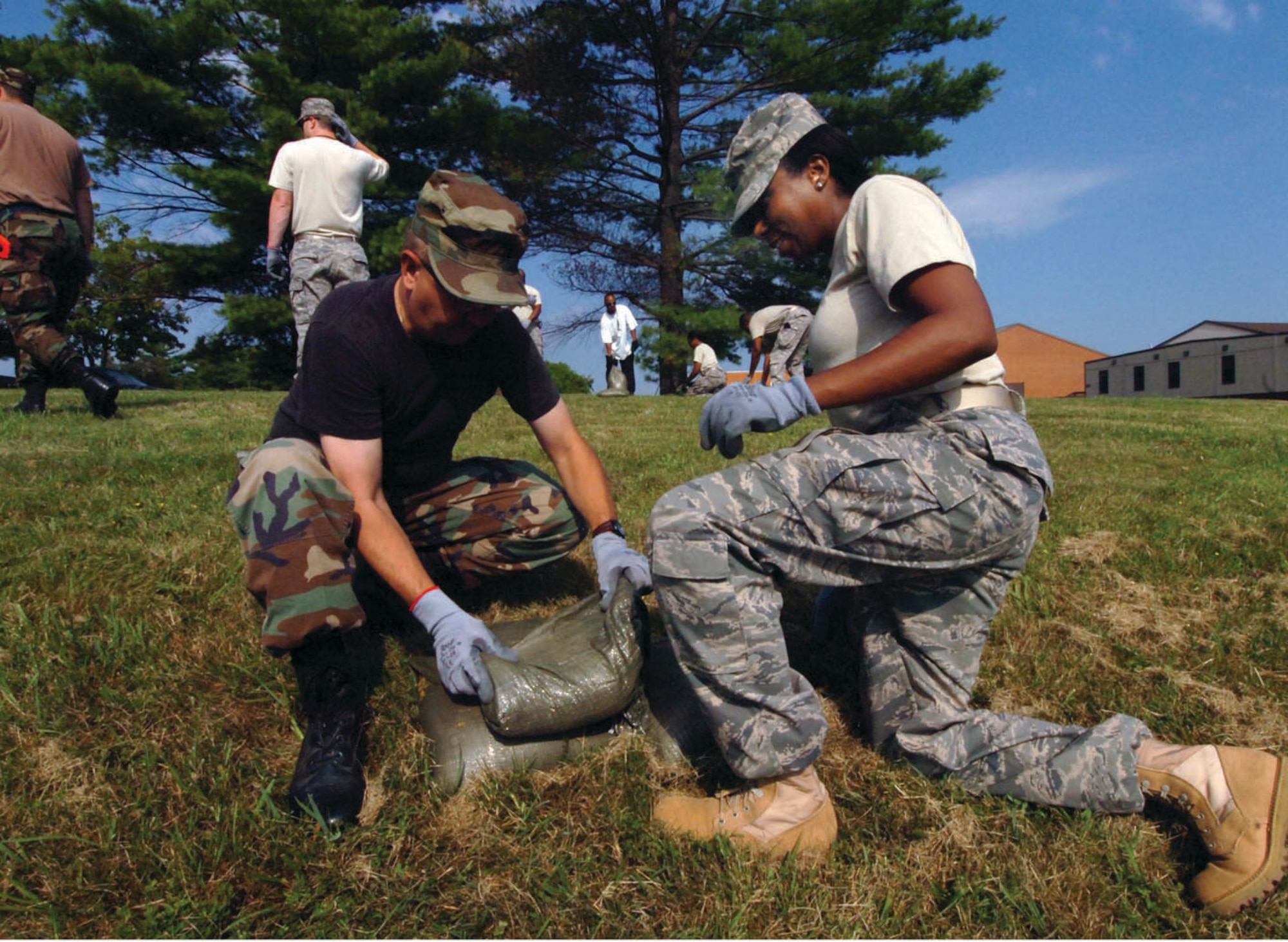 Technical Sgt. James Sparks, left, 113th Wing financial technician, and Tech. Sgt. Jackie Constance, 113th Medical Group medical technician, pack sandbags to form a blast wall perimeter for a tent in preparation for the 113 WG’s upcoming Operational Readiness Inspection. (U.S. Air Force photo/ Bobby Jones)