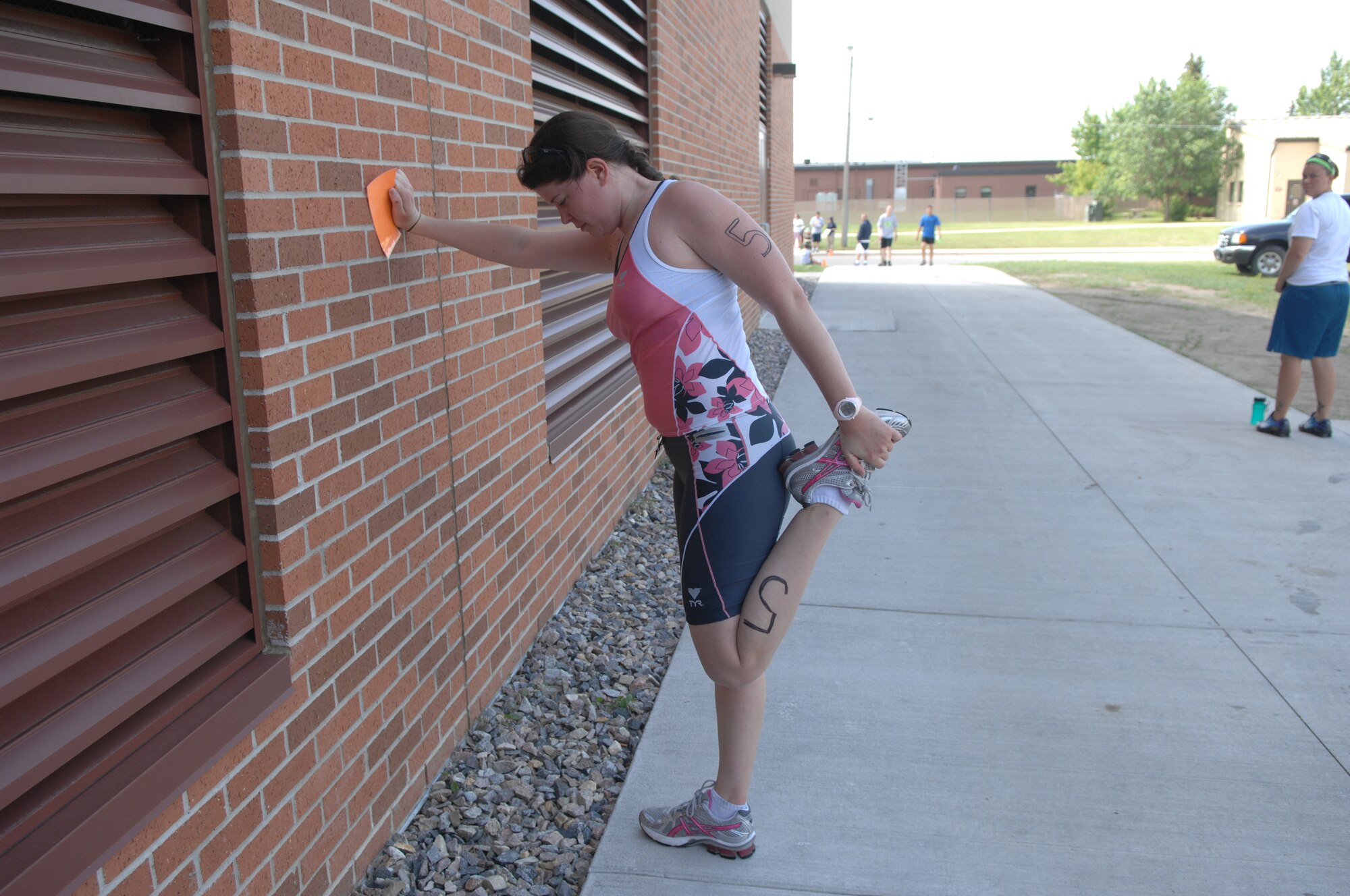 MINOT AIR FORCE BASE, N.D. -- Capt. Kera Rolsen from the 23th Bomb Squadron stretches after the triathlon here July 11. Men and women, civilian and military from across the base participated in the triathlon. The triathlon consists of an one-half mile swim, ten kilometer bicycling, and a five kilometer run.  The 5th Force Support Squadron organized the event to promote physical fitness and team building. (U.S. Air Force photo by Staff Sgt. Angel Gallardo)