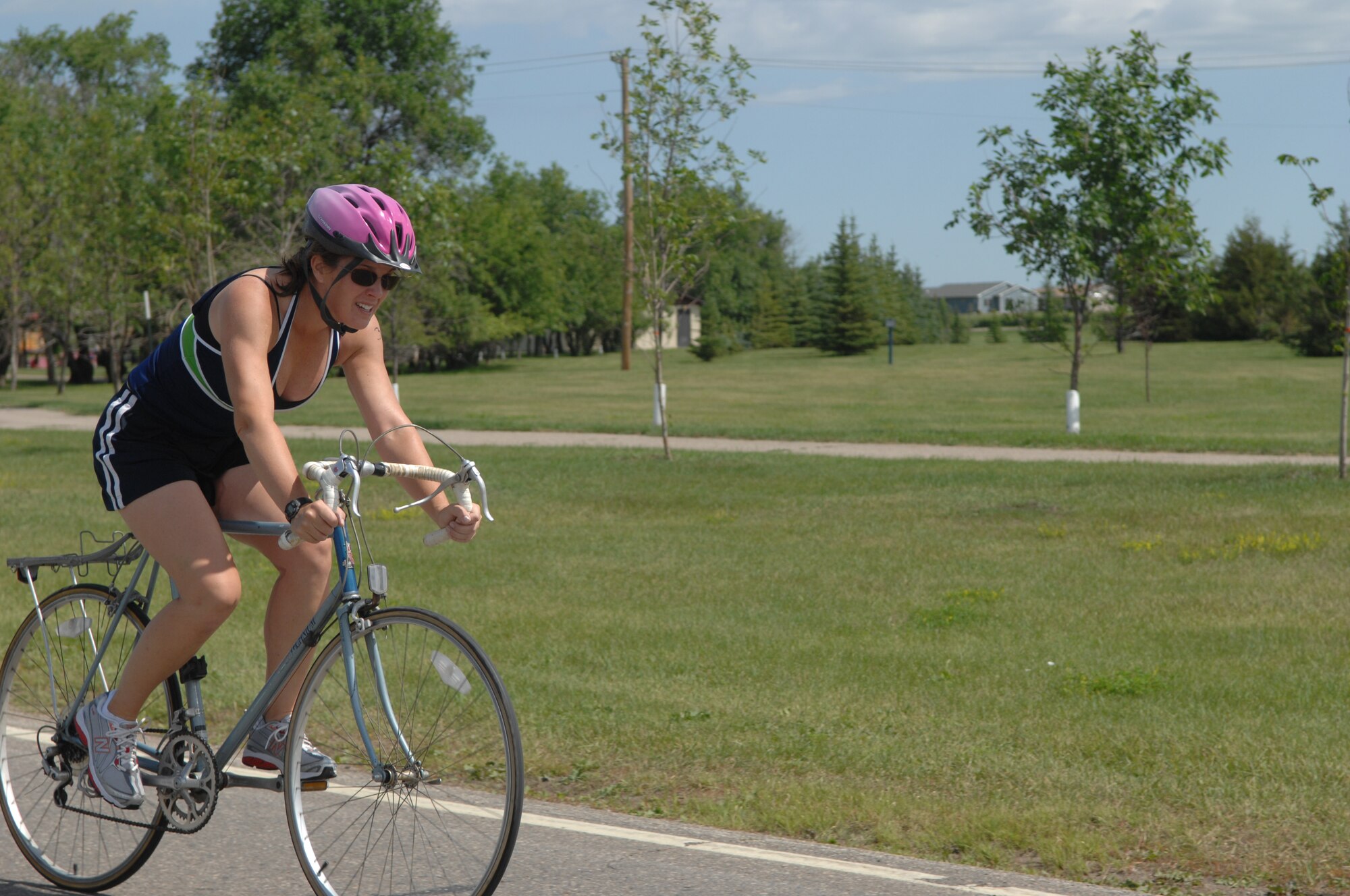 MINOT AIR FORCE BASE, N.D. -- Rebecca Sasseville rides her bicycle at the triathlon here July 11. Men and women, civilian and military from across the base participated in the triathlon. The triathlon consists of an one-half mile swim, ten kilometer bicycling, and a five kilometer run.  The 5th Force Support Squadron organized the event to promote physical fitness and team building. (U.S. Air Force photo by Staff Sgt. Angel Gallardo)