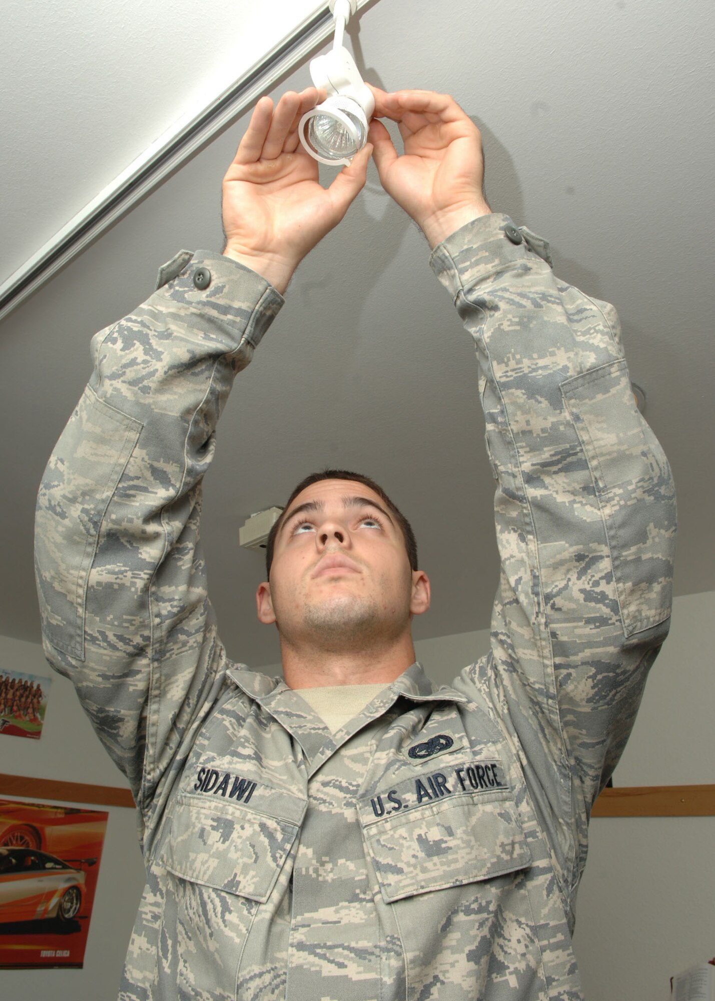 SPANGDAHLEM AIR BASE, Germany – Airman 1st Class Ryan Sidawi replaces a light bulb while performing his bay orderly duties July 9. The bay orderly program ensures all buildings are kept in tip-top shape. Airmen from each dormitory building to leave their normal work sections for five duty days to perform dorm clean-up duty and standby with the dormitory master keys in case someone gets locked out of their room. Airman Sidawi is assigned to the 52nd Communications Squadron (USAF photo by Airman 1st Class Nicholas Wilson)