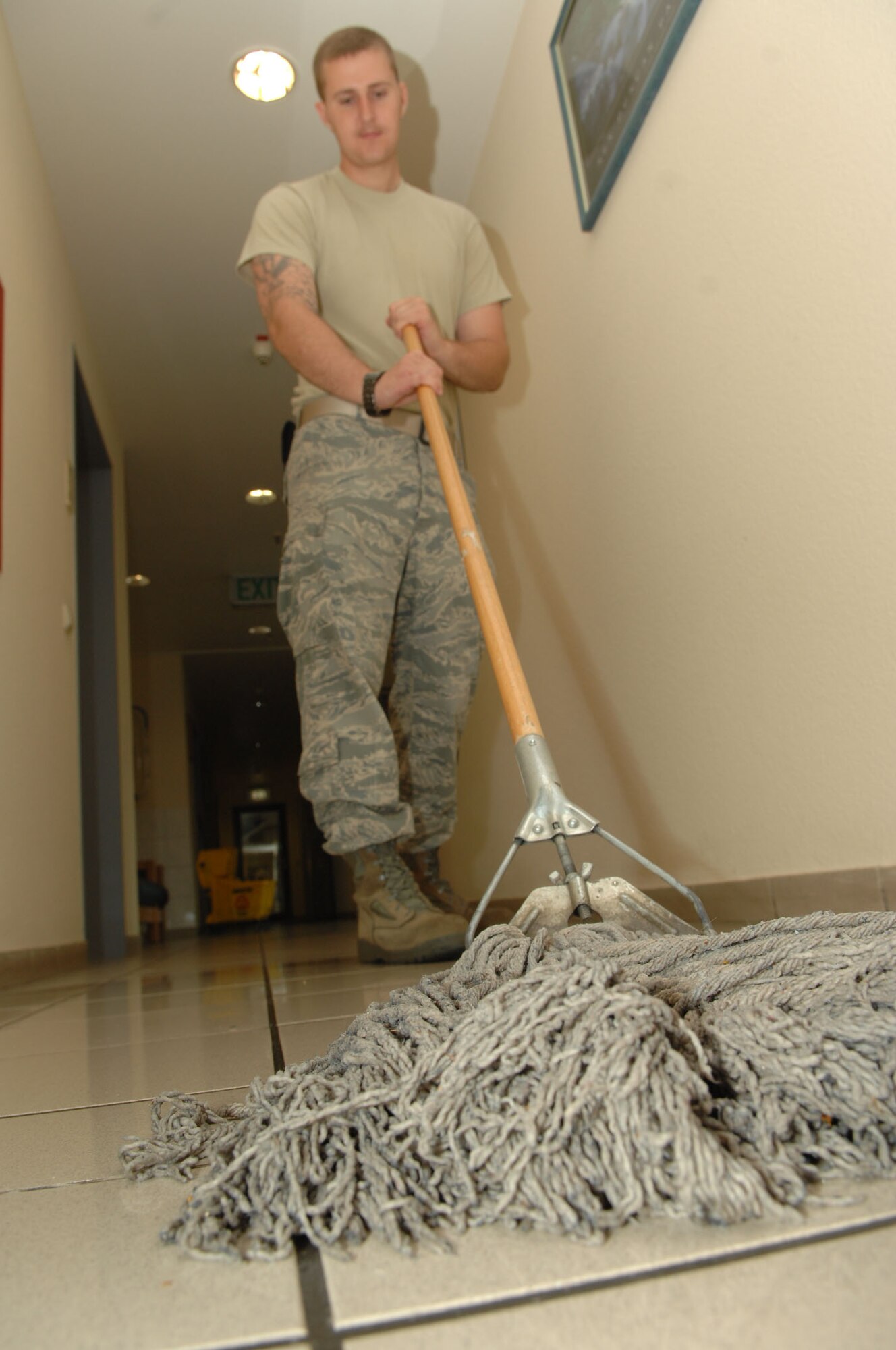 SPANGDAHLEM AIR BASE, Germany – Senior Airman Brandon R. Schwing mops the dorm 227 hallway floor while performing bay orderly duties July 9. Every week, the bay orderly program requires two Airmen from each dormitory building to leave their normal work sections for five duty days to perform dorm clean-up duty and standby with the dormitory master keys in case someone gets locked out of their room. Airman Schwing is assigned to the 52nd Communications Squadron. (USAF photo by Airman 1st Class Nicholas Wilson)