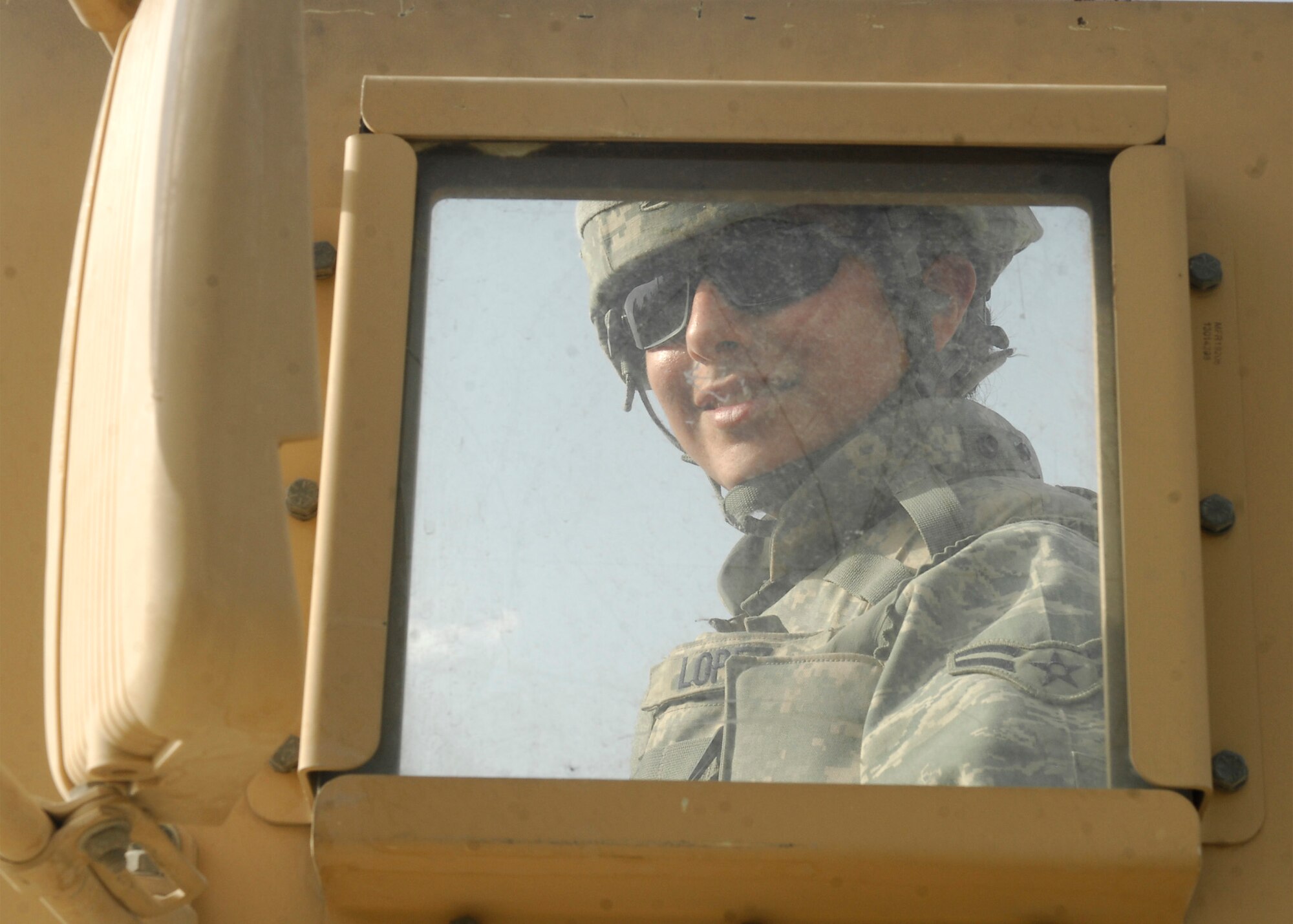 Airman 1st Class Diana Lopez, 455th Expeditionary Security Forces Squadron deployed from Edwards Air Force Base Calif., stays cheerful and happy. She successfully manages to ignore the 70 pound weight of her body armor while patrolling in 90 degree weather. (U.S. Air Force photo/Senior Airman Susan Tracy)