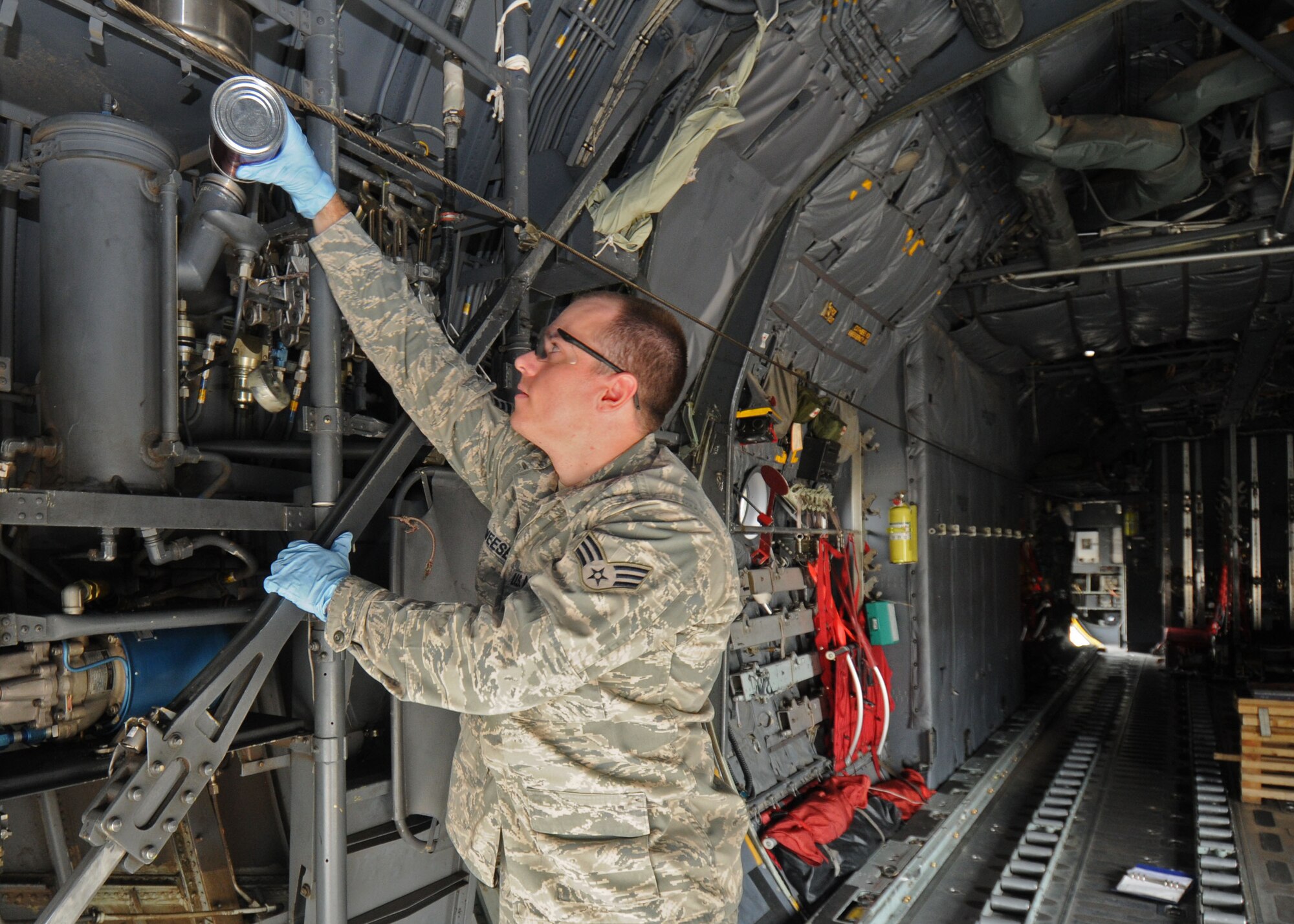YOKOTA AIR BASE, Japan -- Senior Airman Dominic Deweese, 374th Aircraft Maintenance Squadron hydraulics system journeyman, services the auxiliary reservoir on a C-130 with hydraulic fluid. The 374th AMXS has been preparing a C-130 for the 2009 Air Mobility Command Rodeo, which begins July 19 at McChord Air Force Base, Wash. (U.S. Air Force photo/Staff Sgt. Veronica Pierce)
