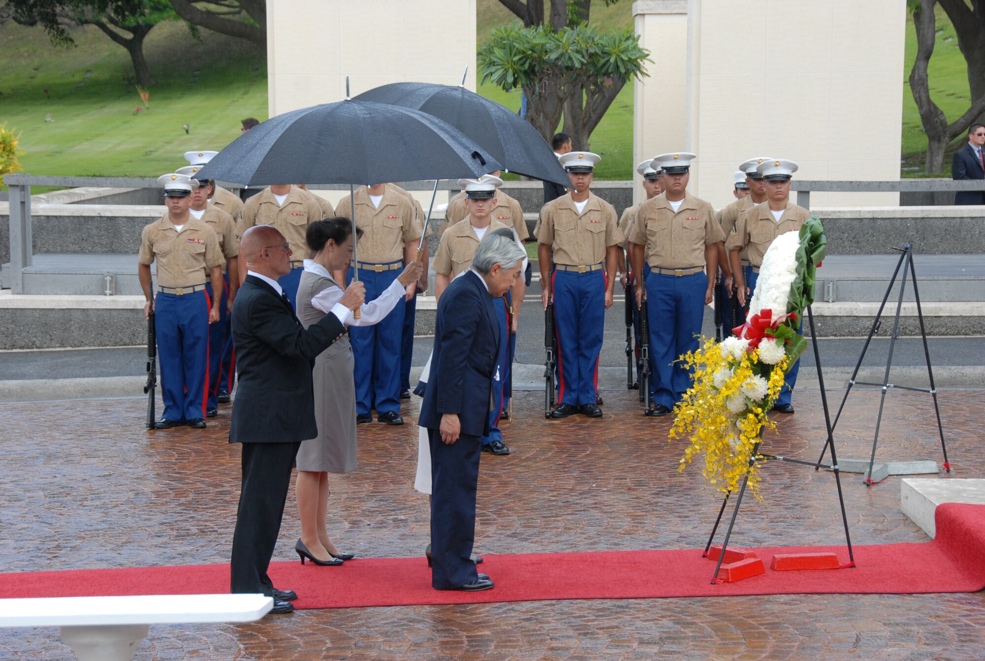 Emperor Akihito and Empress Michiko, the Japanese Imperial Couple, bow to pay tribute to the interred at the National Memorial Cemetery of the Pacific at Punchbowl Crater, Hawaii, July 15. The ceremony included the laying of a chrysanthemum wreath, the playing of "Taps" and a joint flyover by U.S. Navy and Japan Self-Defense Forces aircraft. More than 50,000 service men and women are interred at the cemetery. (U.S. Air Force photo/Staff Sgt. LucCelia Ball)