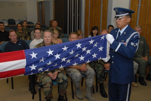 Senior Airman Terrence Mananes, 163d Force Sustainment Squadron and Blue Eagles Honor Guard member, folds the American flag during a retirement ceremony for Master Sgt. Marvin Griffin. (U.S. Air Force photo by Staff Sgt. Diane Ducat)