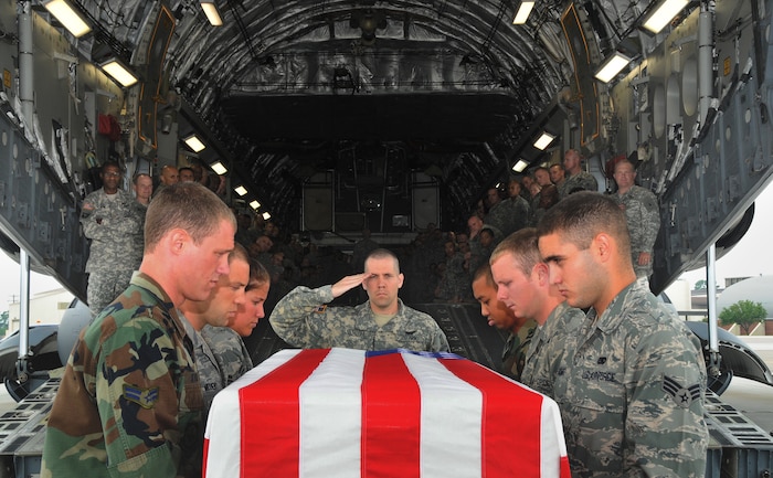 Army Chap. (Capt.) Joseph Odell salutes as a U.S. flag draped transfer case is prepared to be carried aboard a C-17 by Charleston AFB honor guard members on the flightline here July 14 during training for dignified transfers of human remains. More than 170 Army chaplain candidates traveled to Charleston from Fort Jackson, S.C., to take part in the the training event. Chaplain Odell is the class leader for the Chaplain Basic Officer Leader Course, Class 09-002. (U.S. Air Force photo/Staff Sgt. Daniel Bowles)
