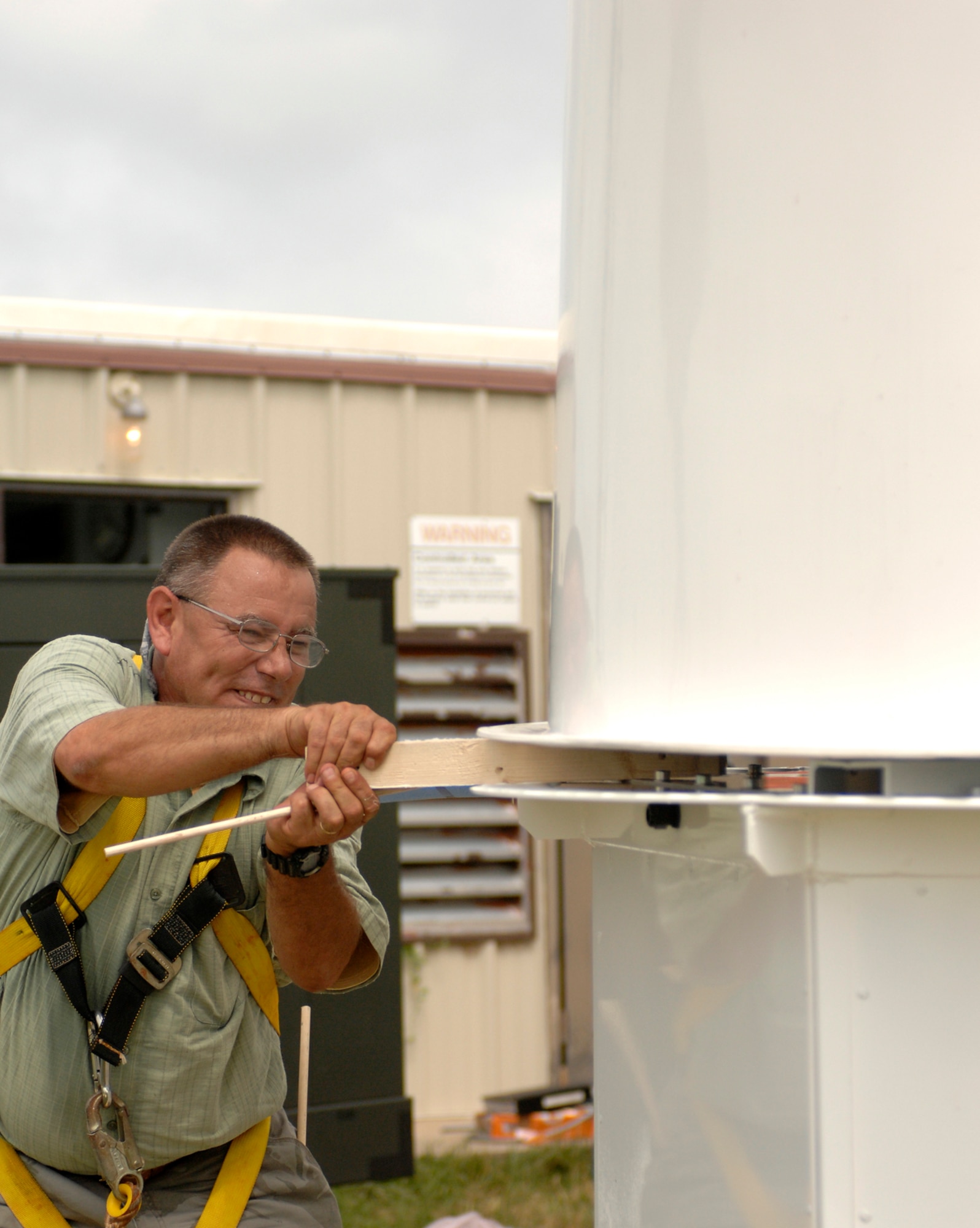WHITEMAN AIR FORCE BASE, Mo. – Stuart Pickell, Science Applications International Corporation field installation manager, removes a spacing board between the top bottom halves of a new Tactical Navigation antenna July 13. TACAN provides pilots with a distance and bearing from a ground or ship-based station. (U.S. Air force photo/Staff Sgt. Jason Barebo)