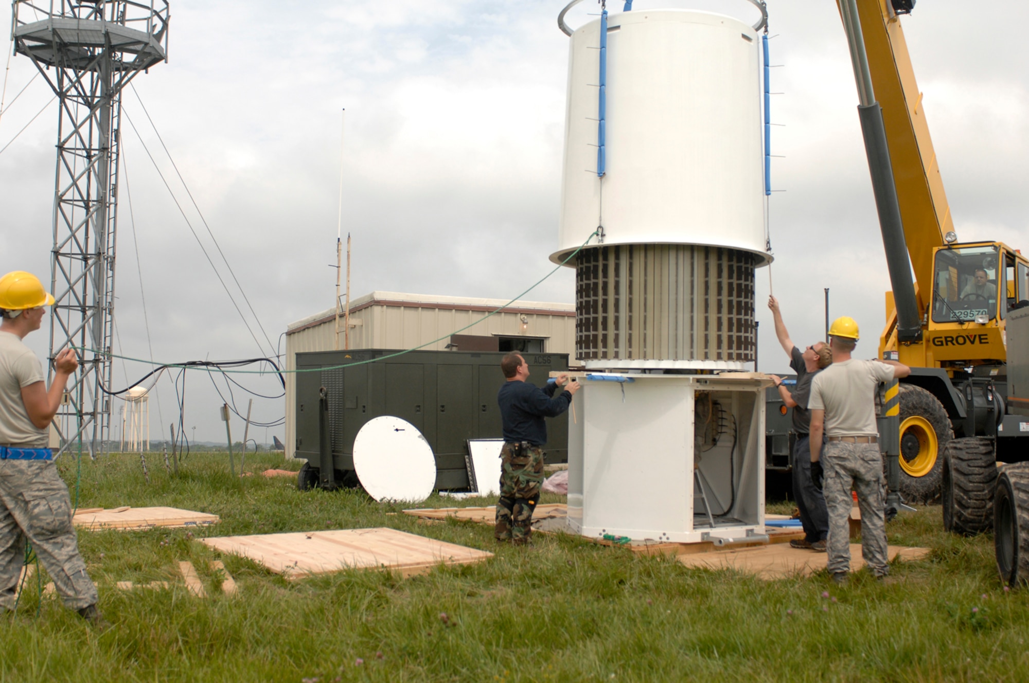 WHITEMAN AIR FORCE BASE, Mo. – Whiteman Airmen and contractors work together to assemble a new Tactical Navigation antenna July 13.  According to the contractors from Science Applications International Corporation it is crucial the inner portion of the antenna not be bent or damaged to ensure reliability. (U.S. Air force photo/Staff Sgt. Jason Barebo)