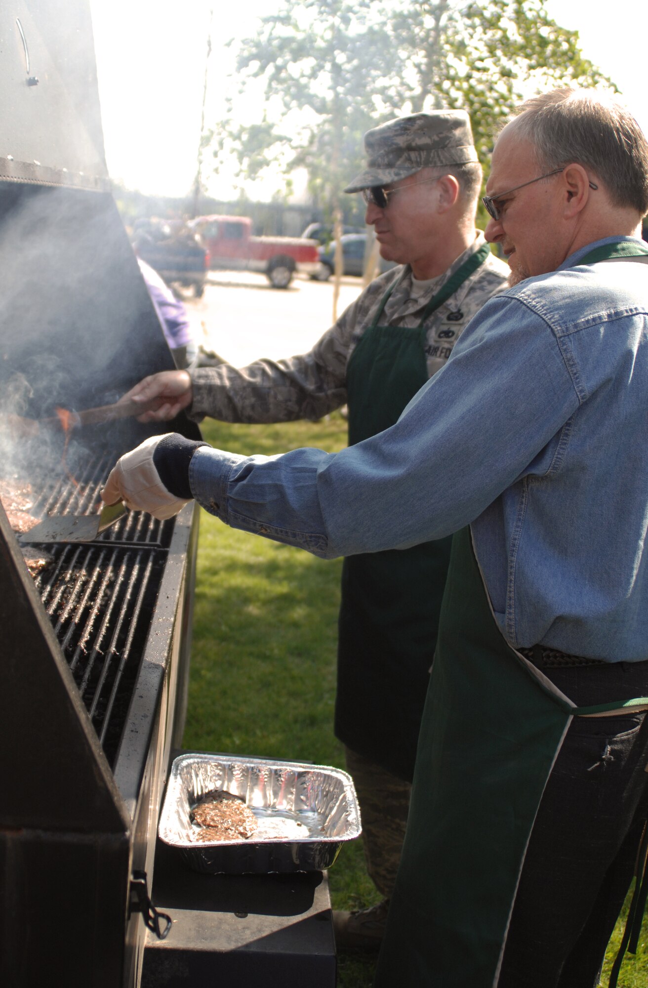 Command Chief Master Sgt. Al Hannon and Brian Newton man the grill during Community Partnership day July 10, 2009 at Fort Wainwright, Alaska. The men were two of the "celebrity chefs" that grilled burgers and hot dogs for volunteers. Cheif Hannon is the 354th Fighter Wing Command Chief and Mr. Newton is the President of the Golden Valley Electric Association.