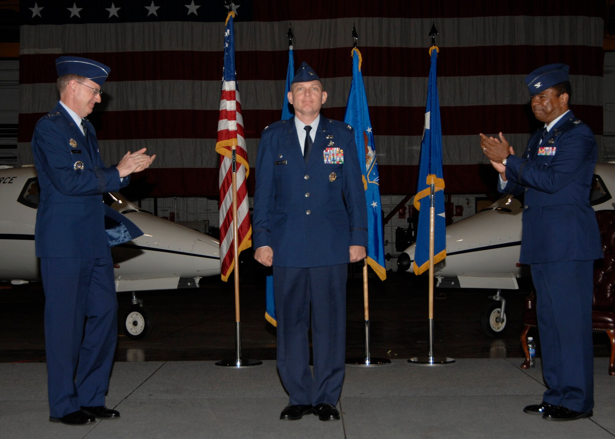 SCOTT AIR FORCE BASE, Ill. -- Gen. Robert Kehler, Air Force Space Command commander, along with Col. Carl Williamson, former AFCA commander, applaud Col. John Odey during the Air Force Network Integration Center change of command July 15.(U.S. Air Force photo/ Airman 1st Class Tristin English) 