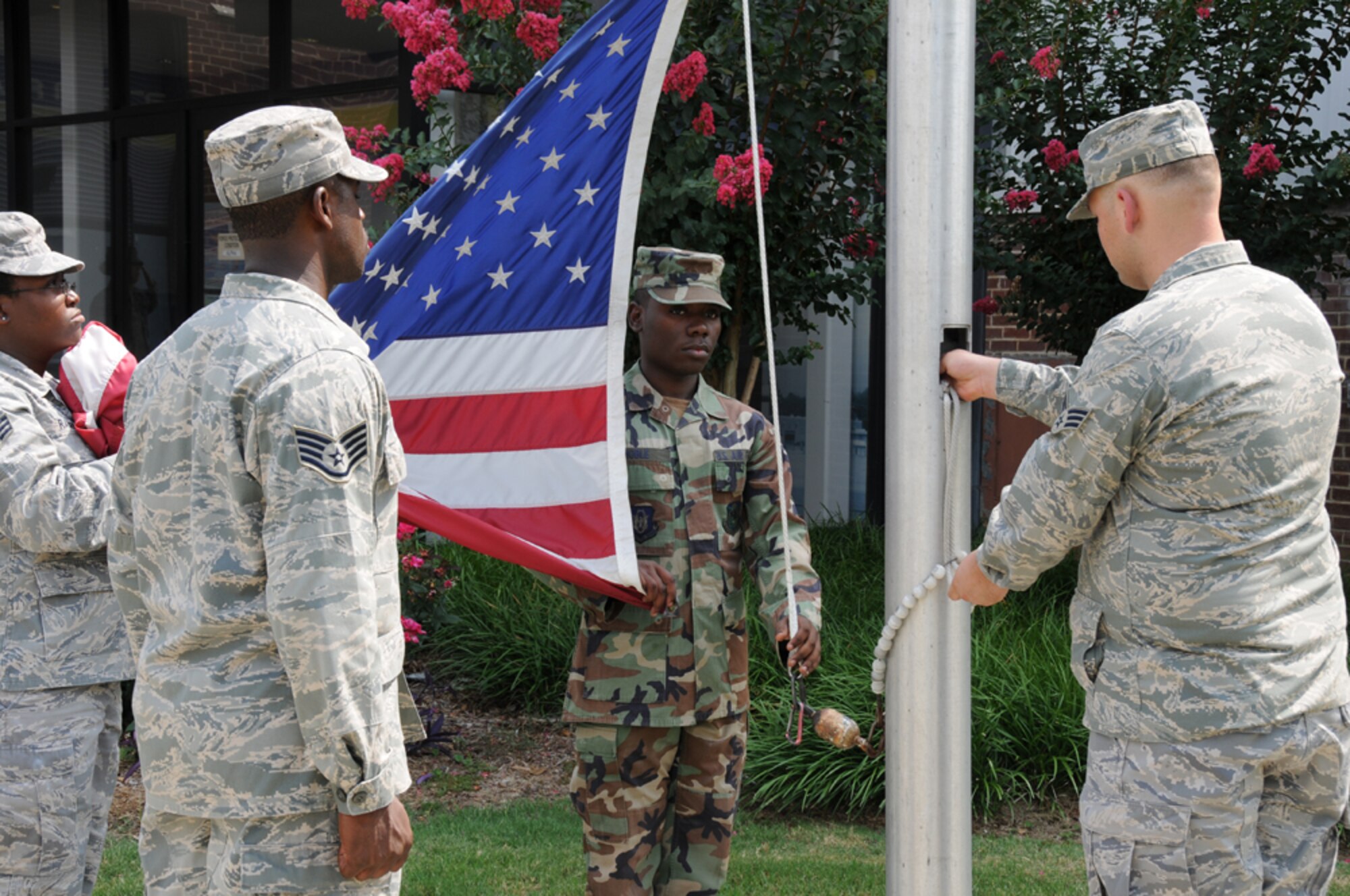 Members of the 94th Aeromedical Staging Squadron lower the flag during a retreat ceremony at the 94th Airlift Wing headquarters building July 11. (U.S. Air Force Photo/Tech. Sgt. Nicholas Ontiveros)