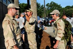 Tech. Sgt. Raymond Pomeroy, left, Staff Sgt. Chris Ferrell and Staff Sgt. Kurt Ziobro, right, take a break to hydrate after running in the Commander's 5K Run/Walk Challenge here July 10 laden with 30 to 40 pound rucksacks. They have been training with their rucksacks for approximately two months to prepare for upcoming deployments to austere locations in the Middle East. The Airmen are with the 437th Civil Engineer Squadron explosives ordnance disposal flight. (U.S. Air Force photo/Staff Sgt. Daniel Bowles)