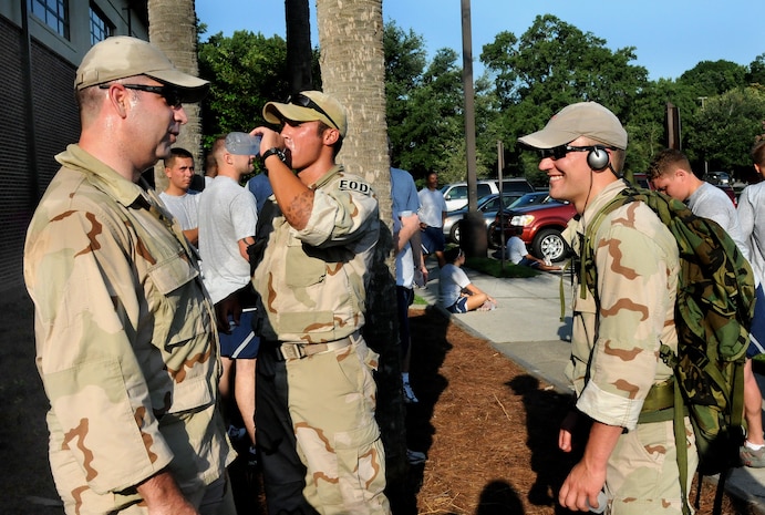 Tech. Sgt. Raymond Pomeroy, left, Staff Sgt. Chris Ferrell and Staff Sgt. Kurt Ziobro, right, take a break to hydrate after running in the Commander's 5K Run/Walk Challenge here July 10 laden with 30 to 40 pound rucksacks. They have been training with their rucksacks for approximately two months to prepare for upcoming deployments to austere locations in the Middle East. The Airmen are with the 437th Civil Engineer Squadron explosives ordnance disposal flight. (U.S. Air Force photo/Staff Sgt. Daniel Bowles)