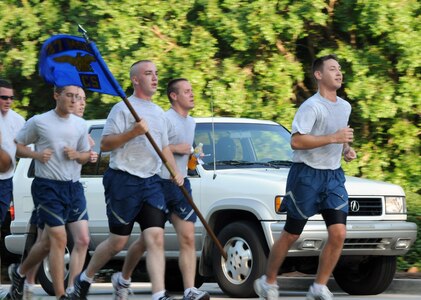 Airmen with the 437th Communications Squadron pace themselves beside vehicles traveling at reduced speeds along Hill Boulevard during the Commander's 5K Run/Walk Challenge here July 10. (U.S. Air Force photo/Staff Sgt. Daniel Bowles)