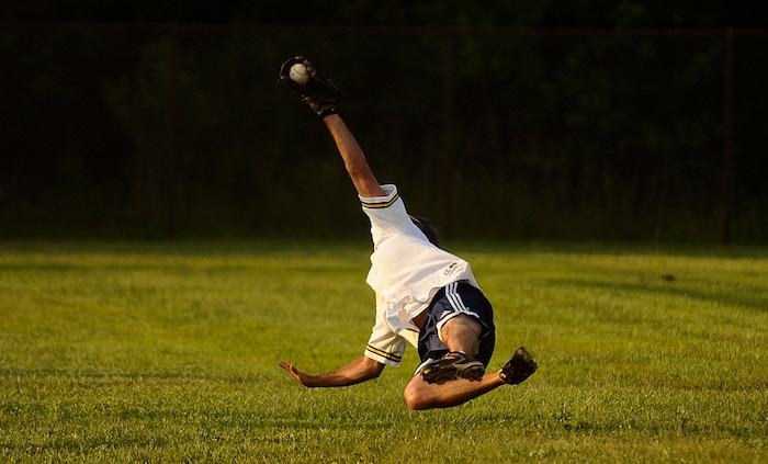 Jeremy Lock of the 1st Combat Camera Squadron makes a diving catch during a softball game against the Aerial Port Squadron July 14. 1CTCS dominated the field Tuesday night as they played a double header against the 437th Aerial Port Squadron they won 10-7 and against the 437th Force Support Squadron they won 10-2. Lock is a combat photographer in the 1 CTCS. (U.S. Air Force photo/ Senior Airman Nicholas Pilch)