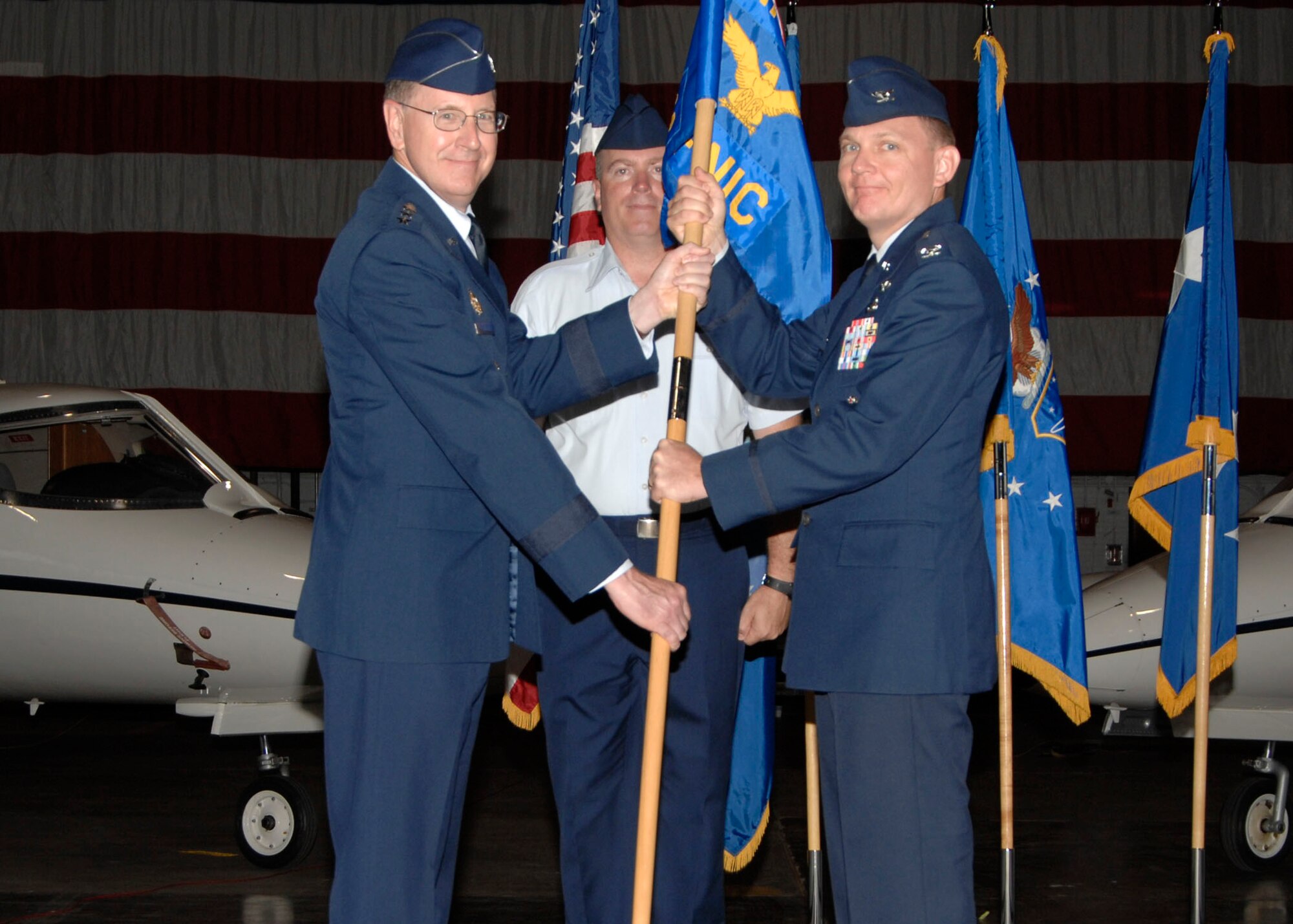 SCOTT AIR FORCE BASE, Ill. -- Gen. Robert Kehler, the commander for Air Force Space Command, presents the new Air Force Network Integration Center guidon to its new commander, Col. John Odey, during a change of command ceremony July 15. Formerly known as the Air Force Communication Agency, the name change more accurately reflects the role it plays in cyberspace operations. (U.S. Air Force photo/ Airman 1st Class Tristin English)