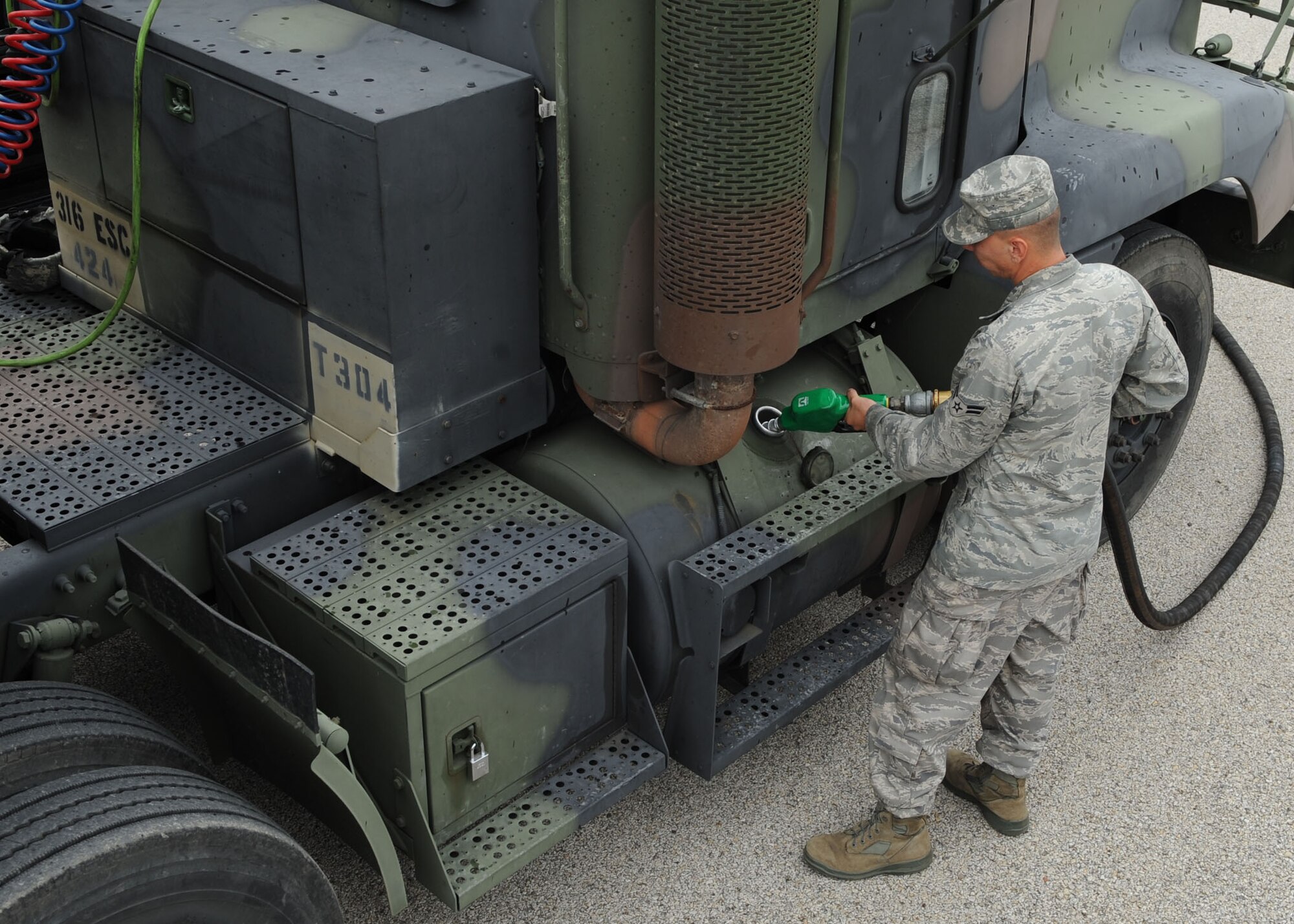 SCOTT AIR FORCE BASE, Ill. -- Airman 1st Class Jerald Dewolf, 375th Logistics Readiness Squadron distribution driver, pumps fuel into one of the U.S. Army vehicles during it’s stop at Scott. The truck is one of many that is taking part of approximately 250 convoy missions running between Crane Army Ammunition Activity, Ind. and Fort Leonard Wood, Mo. (U.S. Air Force photo/ Airman 1st Class Wesley Farnsworth)