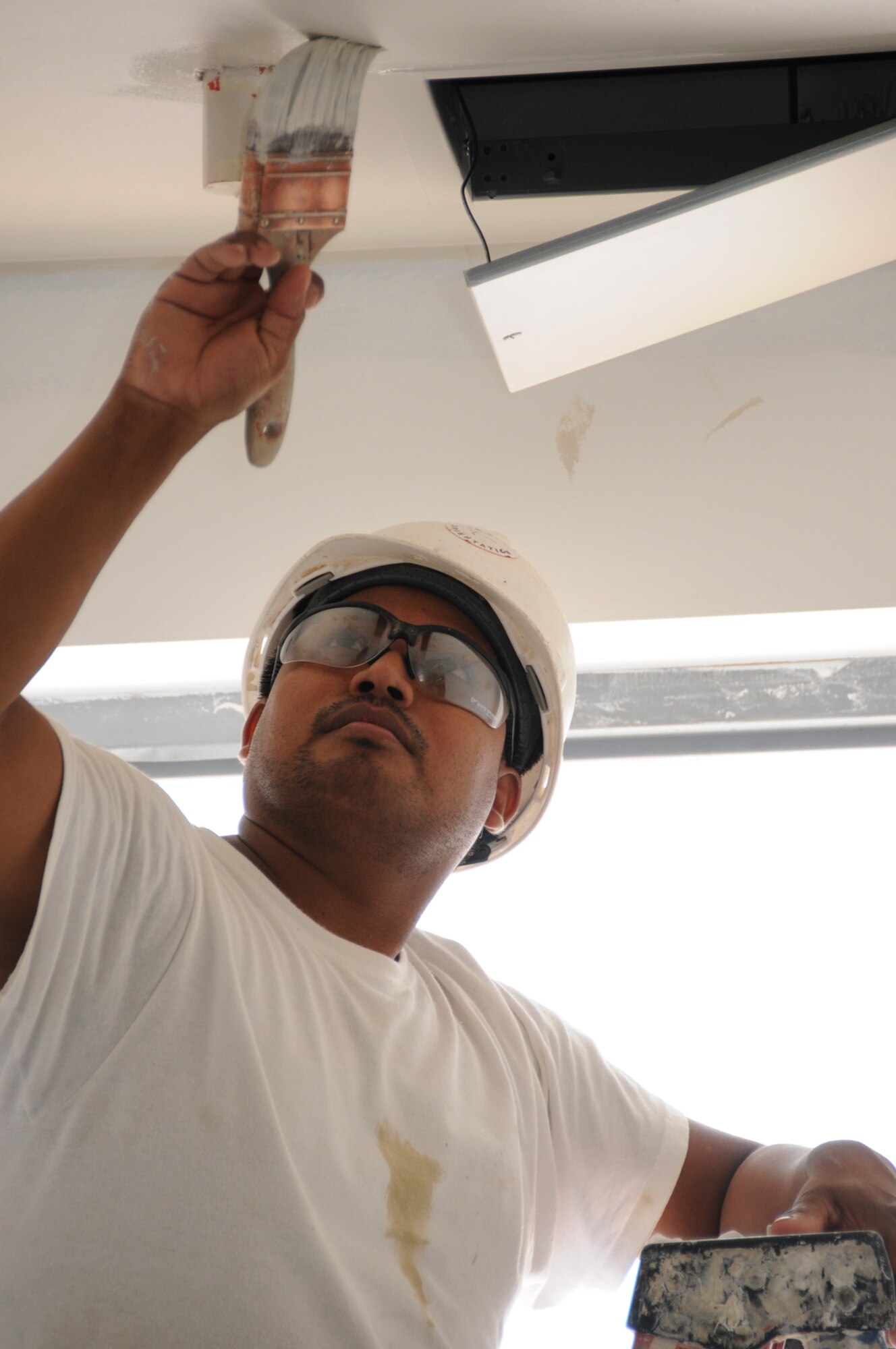 Olegareo Torres paints the inside of the new commissary.  (U.S. Air Force photo by Kemberly Groue)