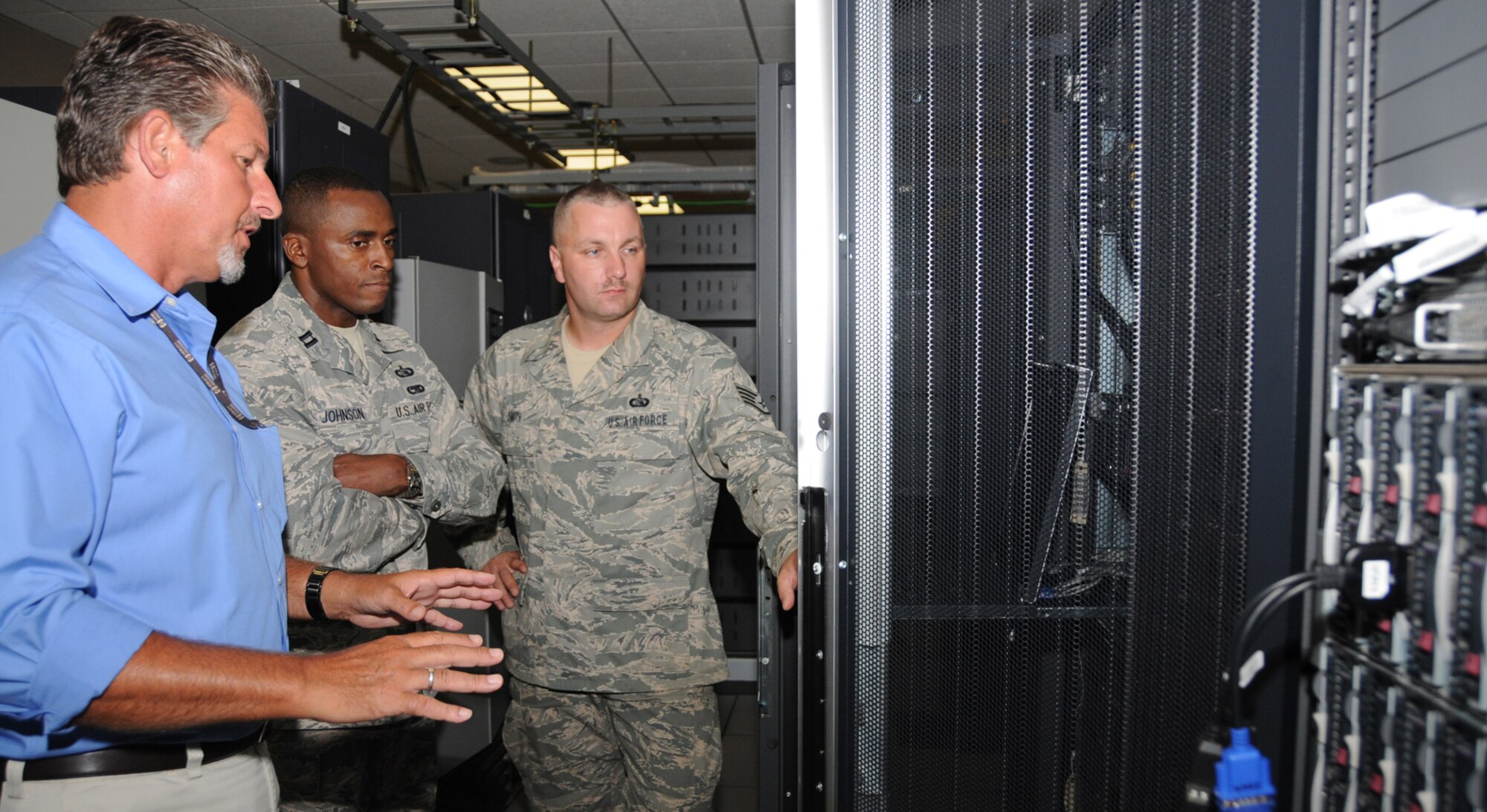 Rupert Bradshaw, left, Capt. Andre Johnson and Staff Sgt. Jason Smith discuss the 81st Communication Squadron’s network storage July 8.  Captain Johnson, the squadron’s former operations officer, assumed command July 2 from Lt. Col. Ray Adams.  Colonel Adams is now the 81st Training Group’s deputy commander.  (U.S. Air Force photo by Kemberly Groue)