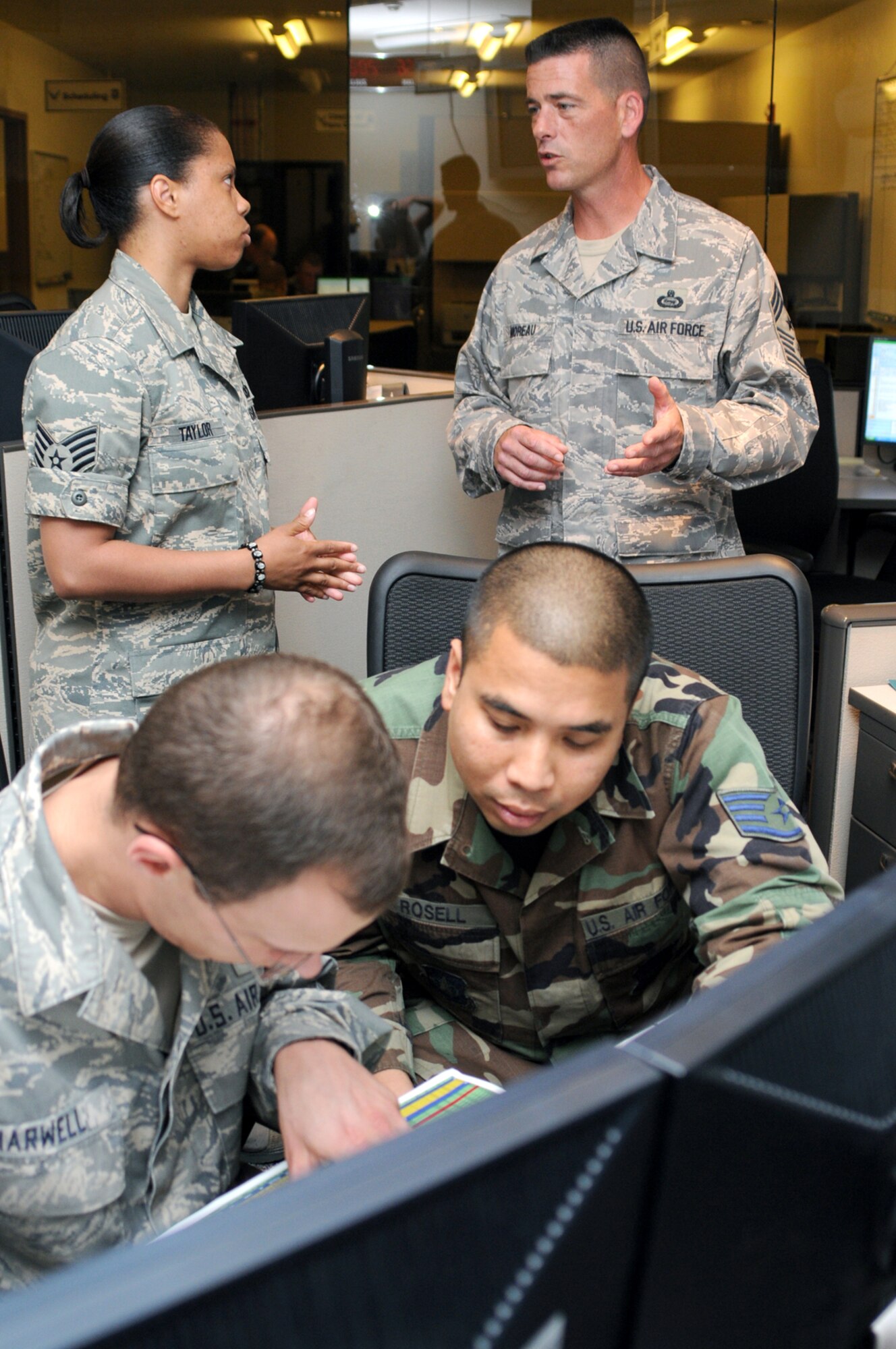 Staff Sgt. Candice Taylor, top left, talks to Chief Moreau shortly after his arrival at Keesler during his introduction to the 602nd Training Group’s combat skills training.  In the foreground are Tech. Sgt. James Harwell, left, and Staff Sgt. Zuri Rosell.  (u.S. Air Force photo by Kemberly Groue)