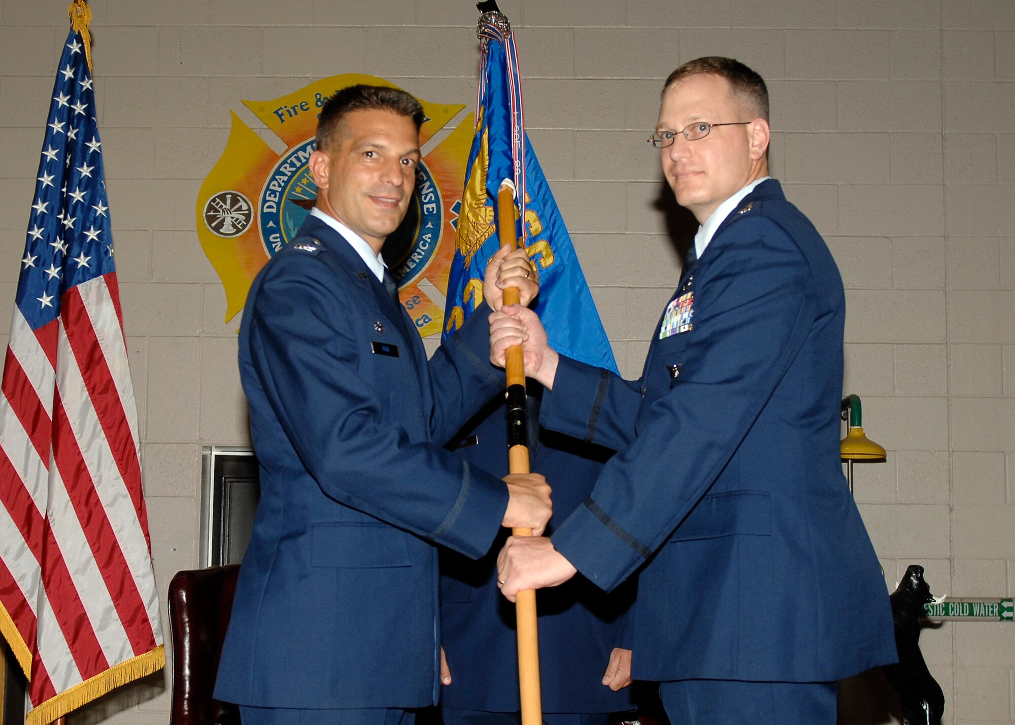 MCCONNELL AIR FORCE BASE, Kan. -- Colonel Pat Rose, 22nd Mission Support Group commander, hands the guidon to Lt. Col. Louis Lilley, the gaining 22nd Civil Engineer Squadron commander, during the Civil Engineer Squadron change of command ceremony at the fire station, July 9. Colonel Lilley takes the guidon to symbolize his assumption of command. (Photo by Senior Airman Anthony Mejia)